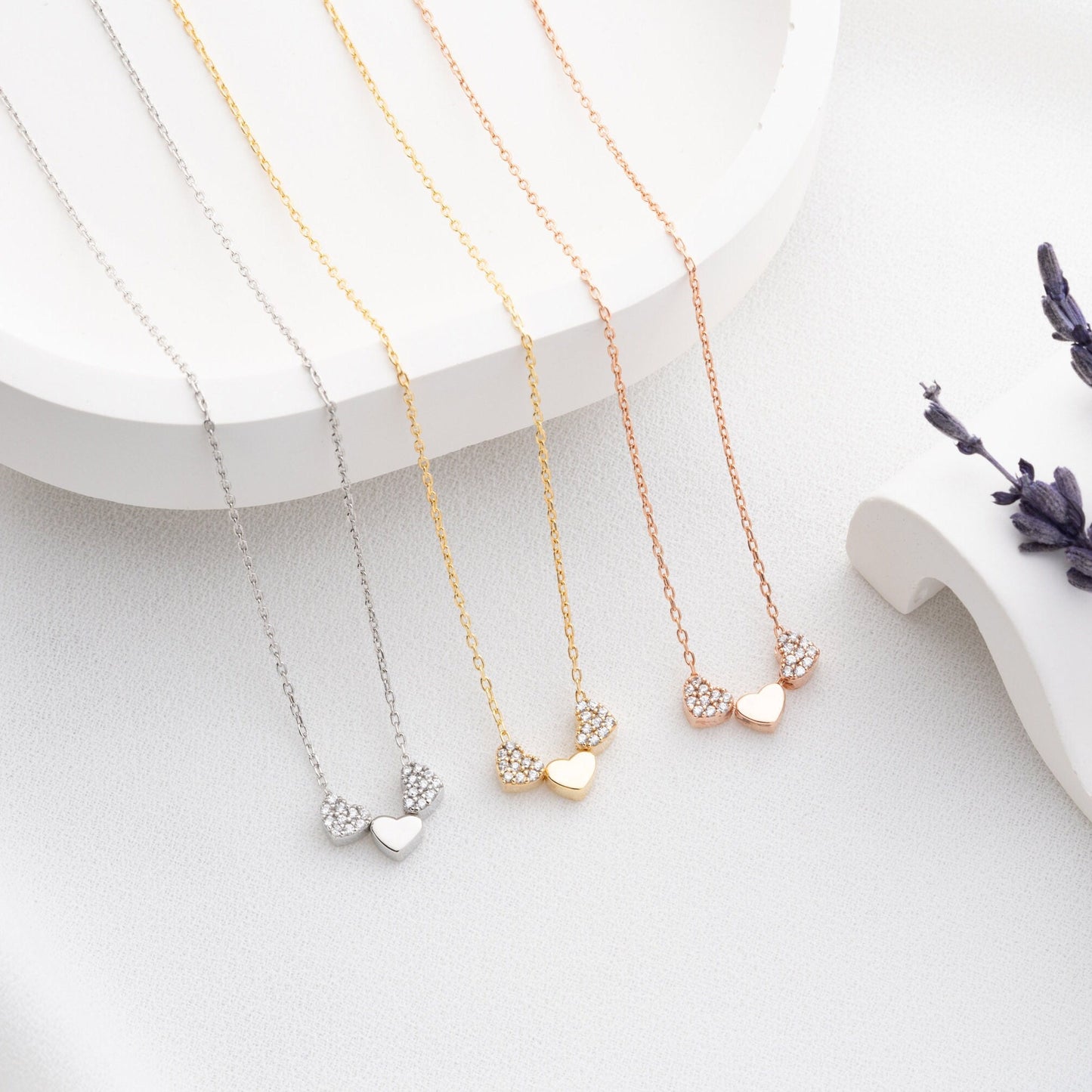 An exquisite silver necklace featuring three interlocking hearts, each heart intricately detailed with sparkling zircon stones, creating a luxurious and romantic piece perfect for gifting on special occasions or expressing love and affection.