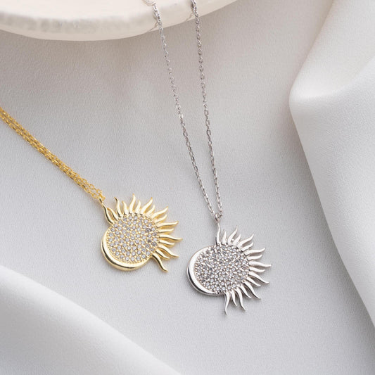 Sun pendant necklace with cubic zirconia stones, available in 925 sterling silver and 14K gold plated options, displayed on a white satin background
