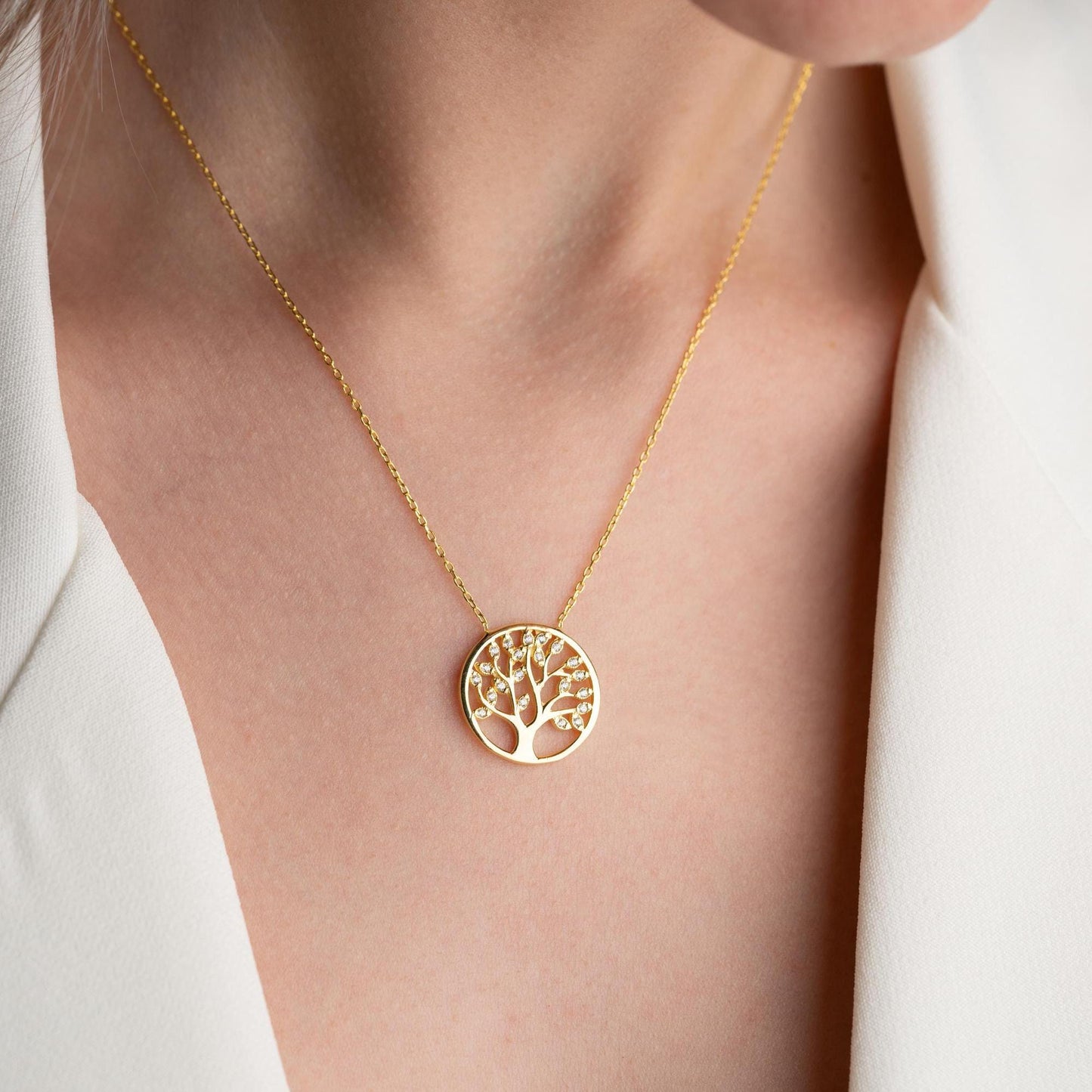 Tree of Life pendant necklace with cubic zirconia stones, available in 925 sterling silver and 14K gold plated options, displayed on a white satin background