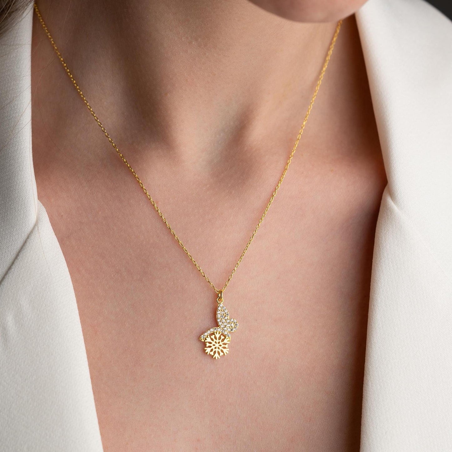 Snowflake heart necklace with cubic zirconia stones, available in 925 sterling silver and 14K gold plated options, displayed on a white satin background