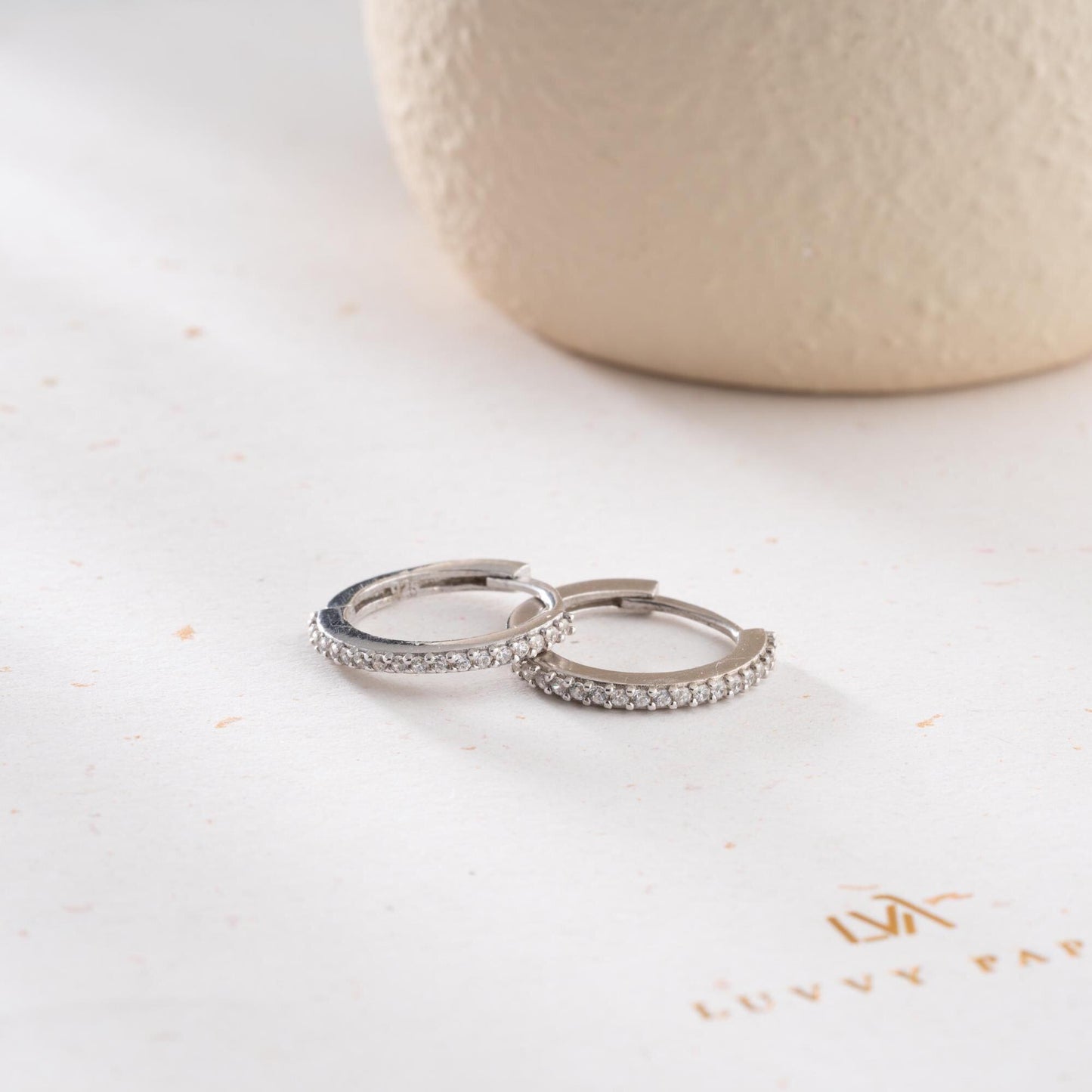 Minimalist hoop earrings with cubic zirconia stones in 925 sterling silver and 14K gold plated options, displayed on a neutral background.