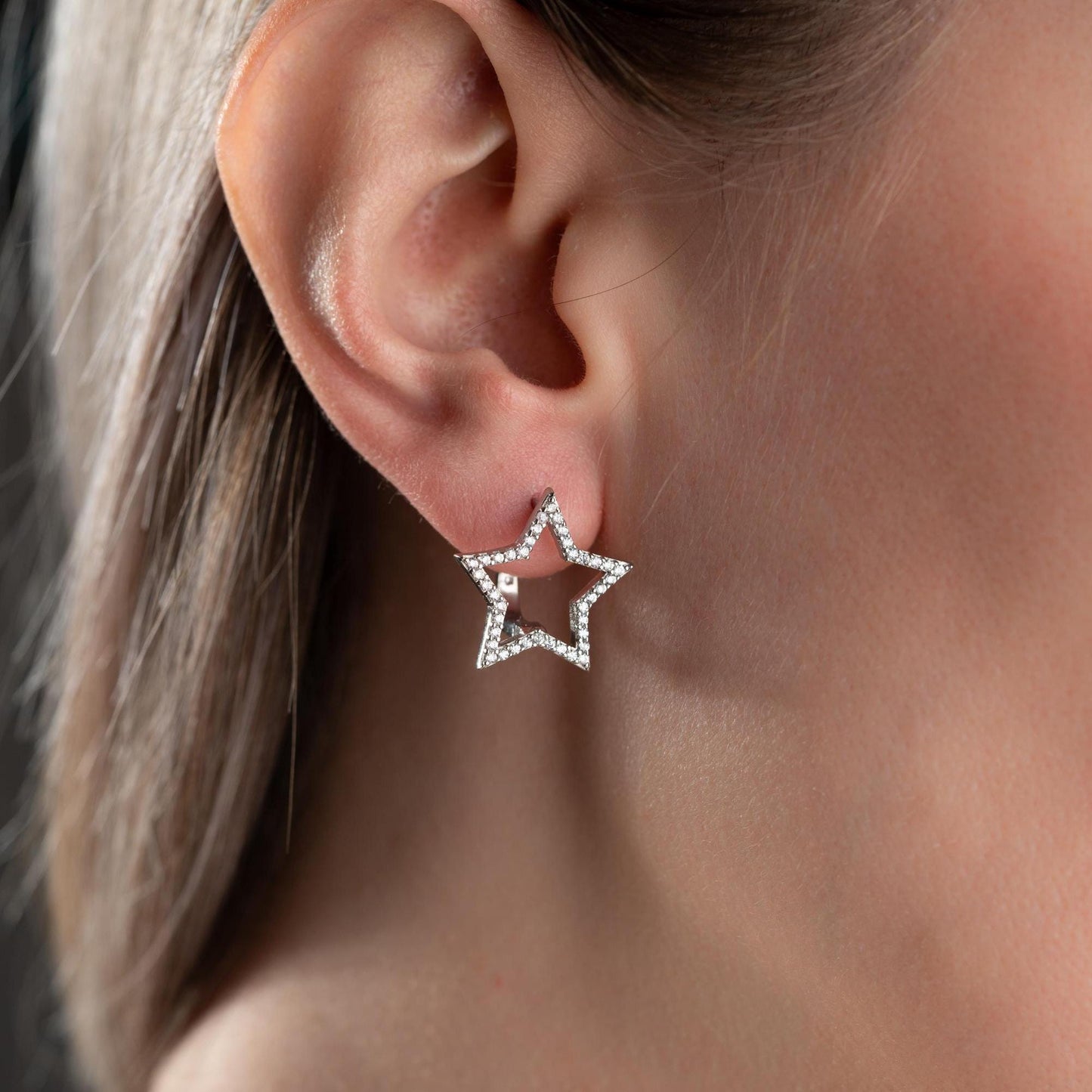 Star-shaped earrings with cubic zirconia stones, available in 925 sterling silver and 14K gold plated options, displayed on a minimalist background.