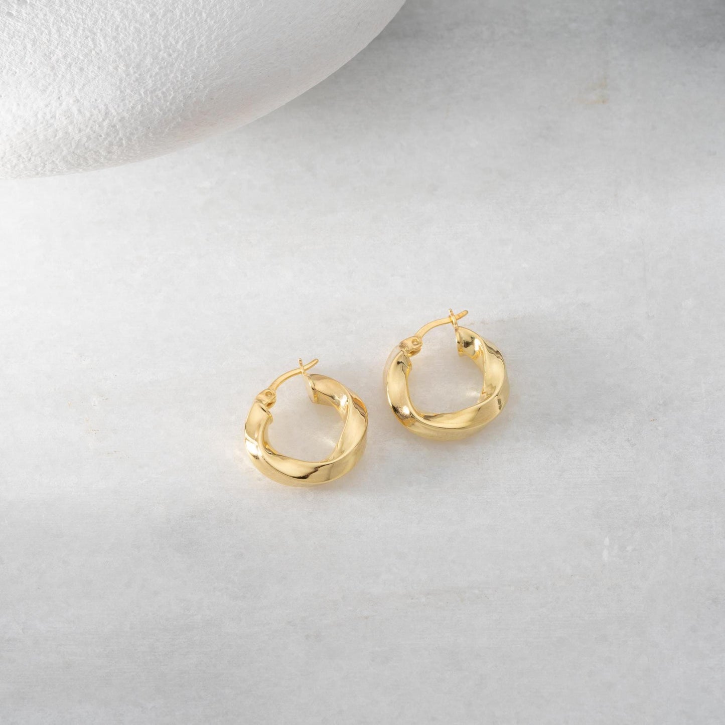 Twist hoop earrings in 925 Sterling Silver and 14K Gold Plated options, perfect for minimalist and elegant looks.