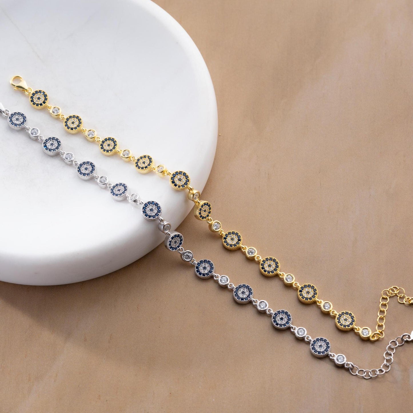 Evil Eye Charm Bracelet crafted in 925 Sterling Silver with cubic zirconia stones and intricate evil eye motifs, available in gold and silver finishes.