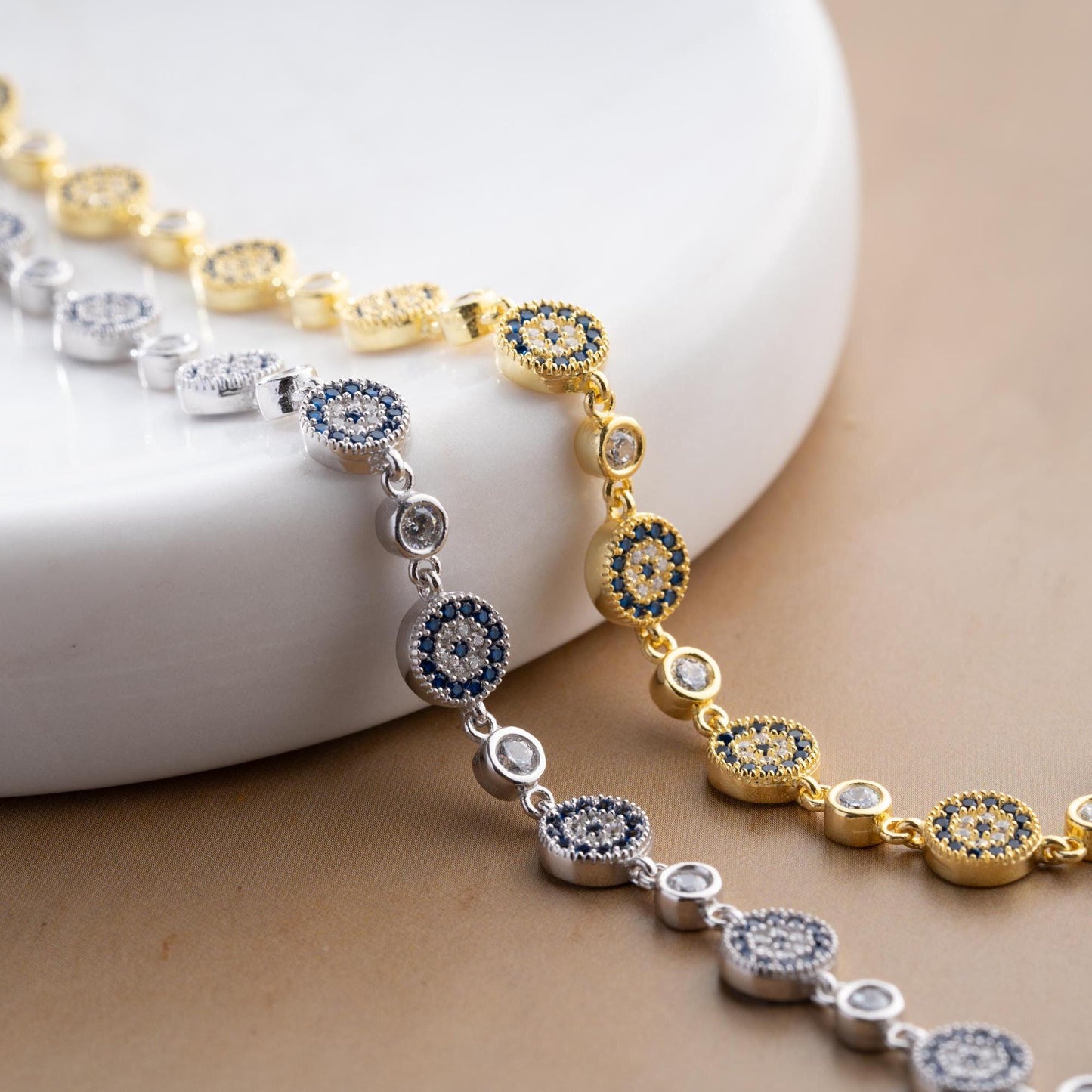Evil Eye Charm Bracelet crafted in 925 Sterling Silver with cubic zirconia stones and intricate evil eye motifs, available in gold and silver finishes.