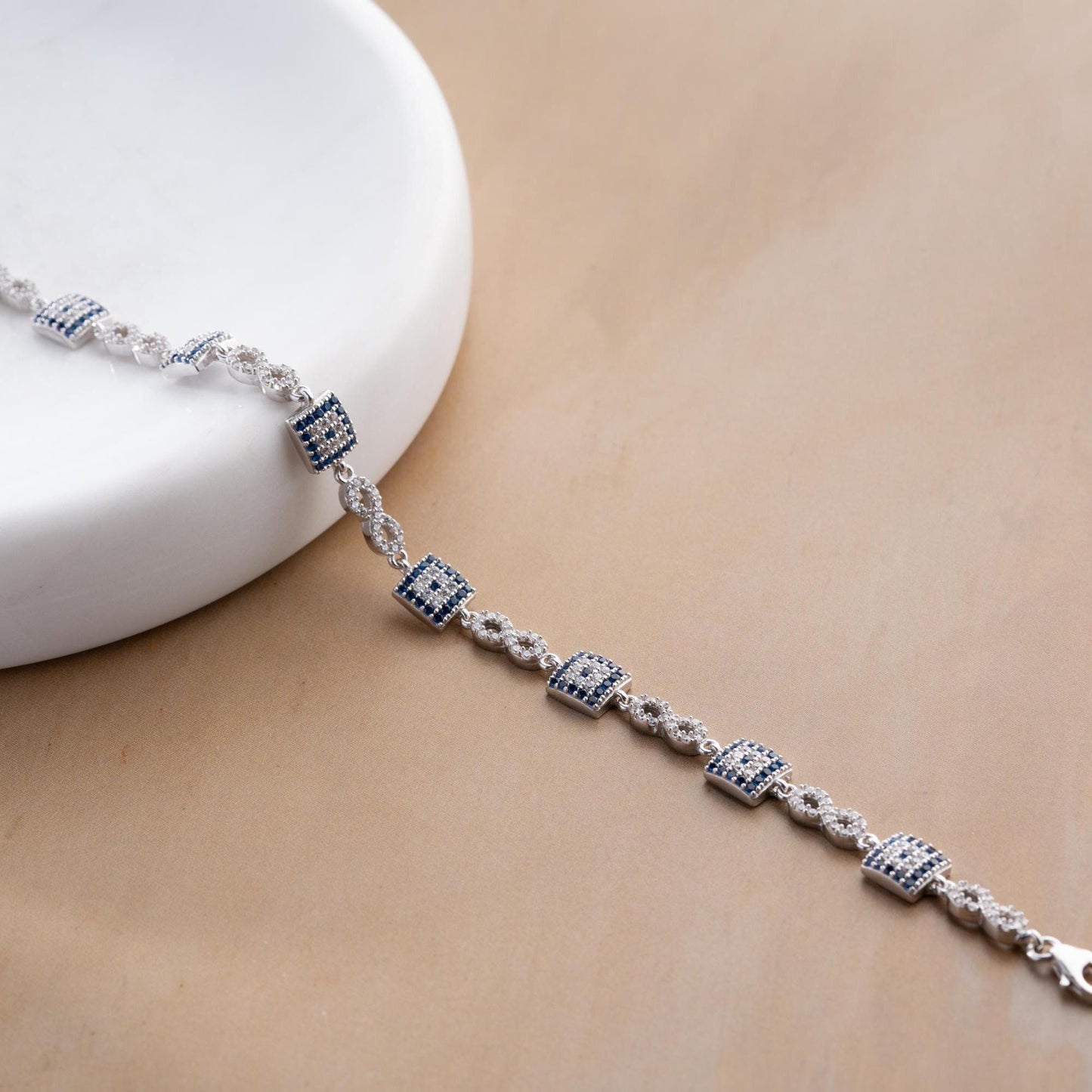 Elegant charm bracelet featuring square evil eye motifs and infinity symbols, crafted in 925 Sterling Silver with cubic zirconia stones, available in silver and gold finishes, perfect for festive gifting.