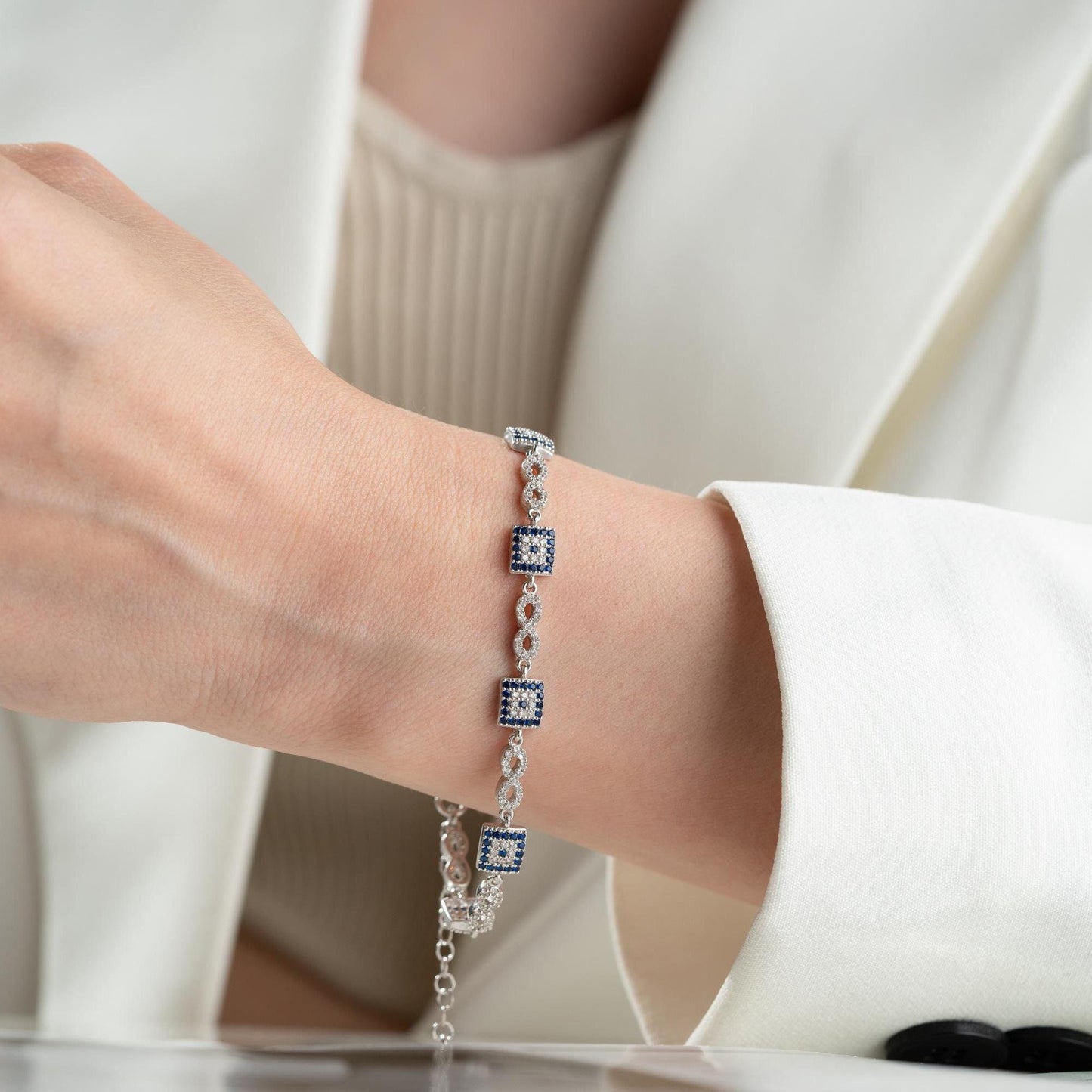 Elegant charm bracelet featuring square evil eye motifs and infinity symbols, crafted in 925 Sterling Silver with cubic zirconia stones, available in silver and gold finishes, perfect for festive gifting.