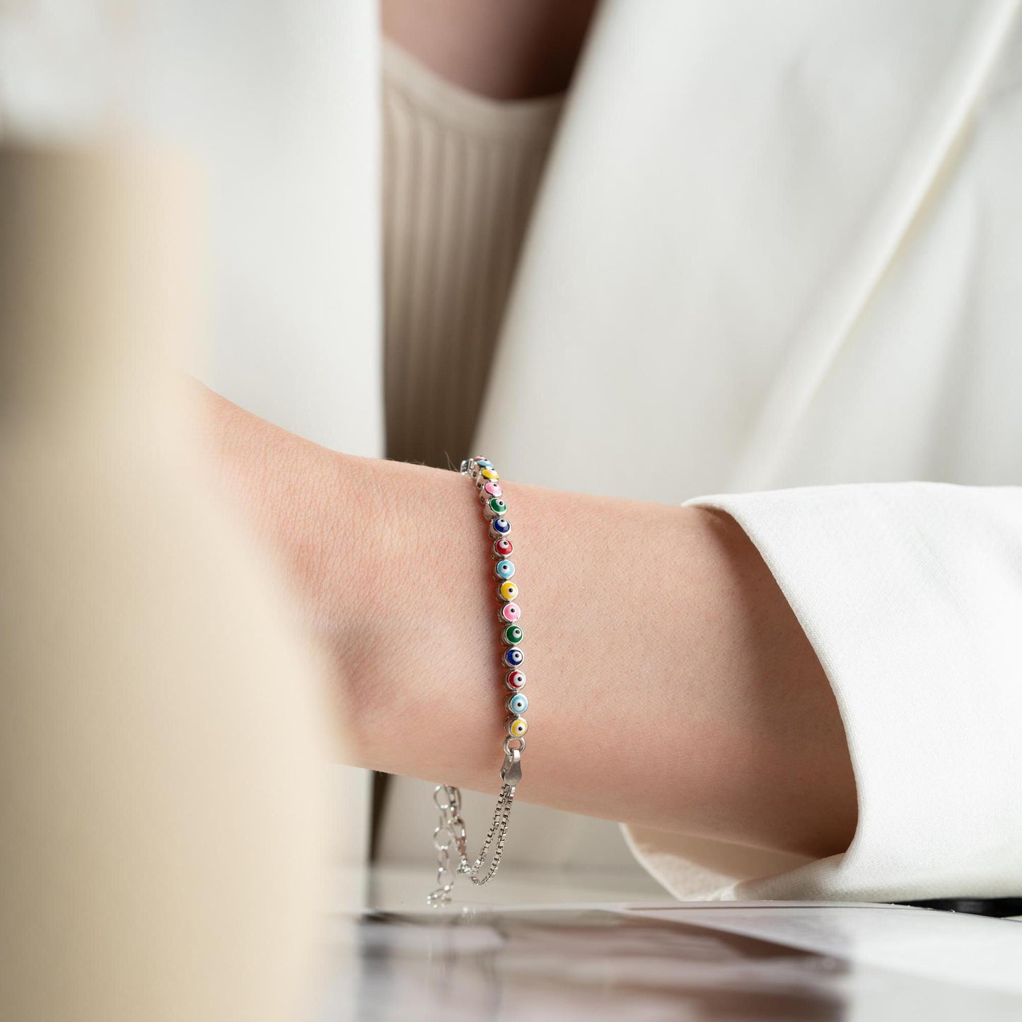 Vibrant charm bracelet featuring multicolored evil eye designs, crafted in 925 Sterling Silver, available in silver and gold finishes, perfect for gifting.