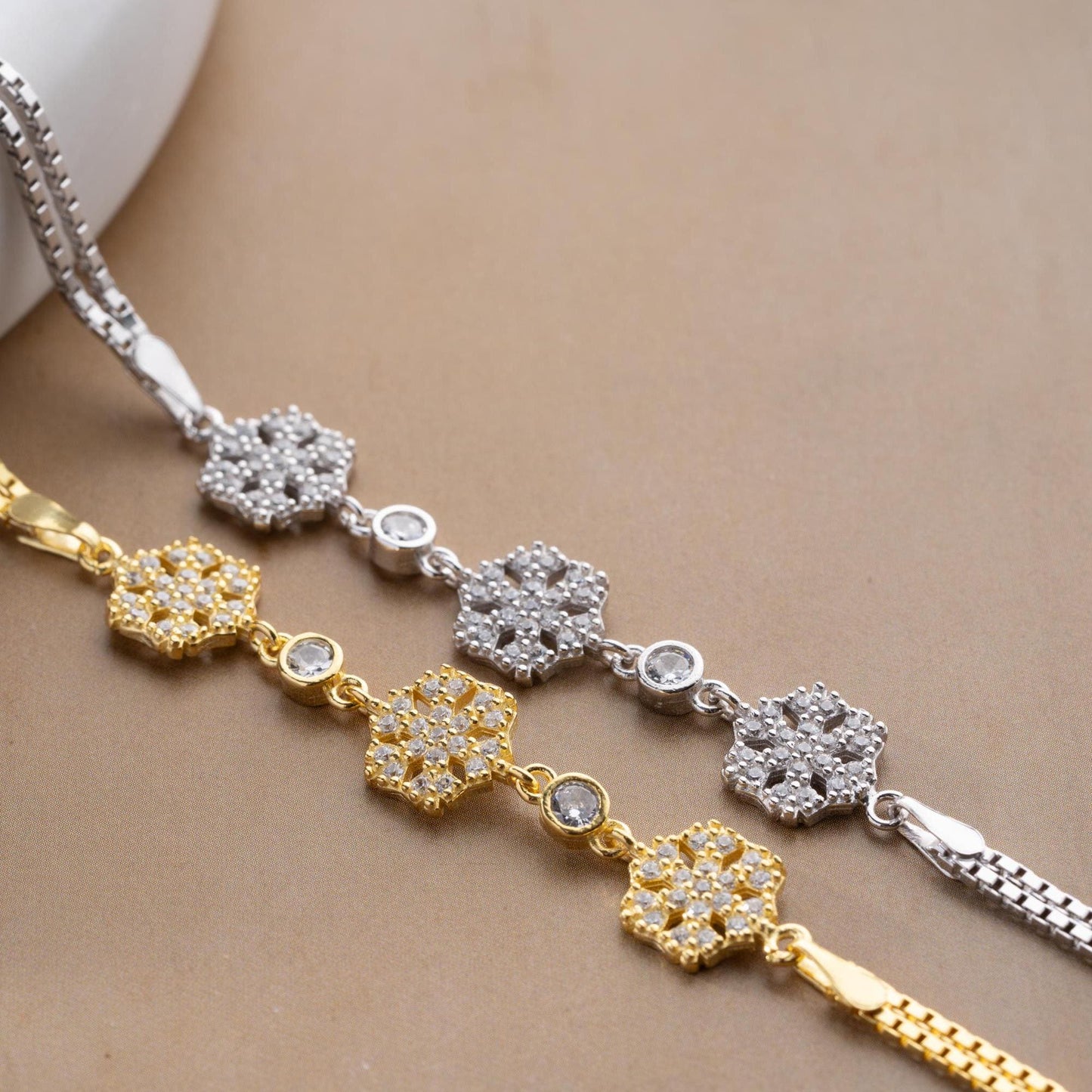 Elegant snowflake charm bracelet crafted in 925 Sterling Silver with cubic zirconia stones, available in silver and gold finishes, perfect for winter gifting.