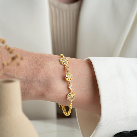 Elegant snowflake charm bracelet crafted in 925 Sterling Silver with cubic zirconia stones, available in silver and gold finishes, perfect for winter gifting.