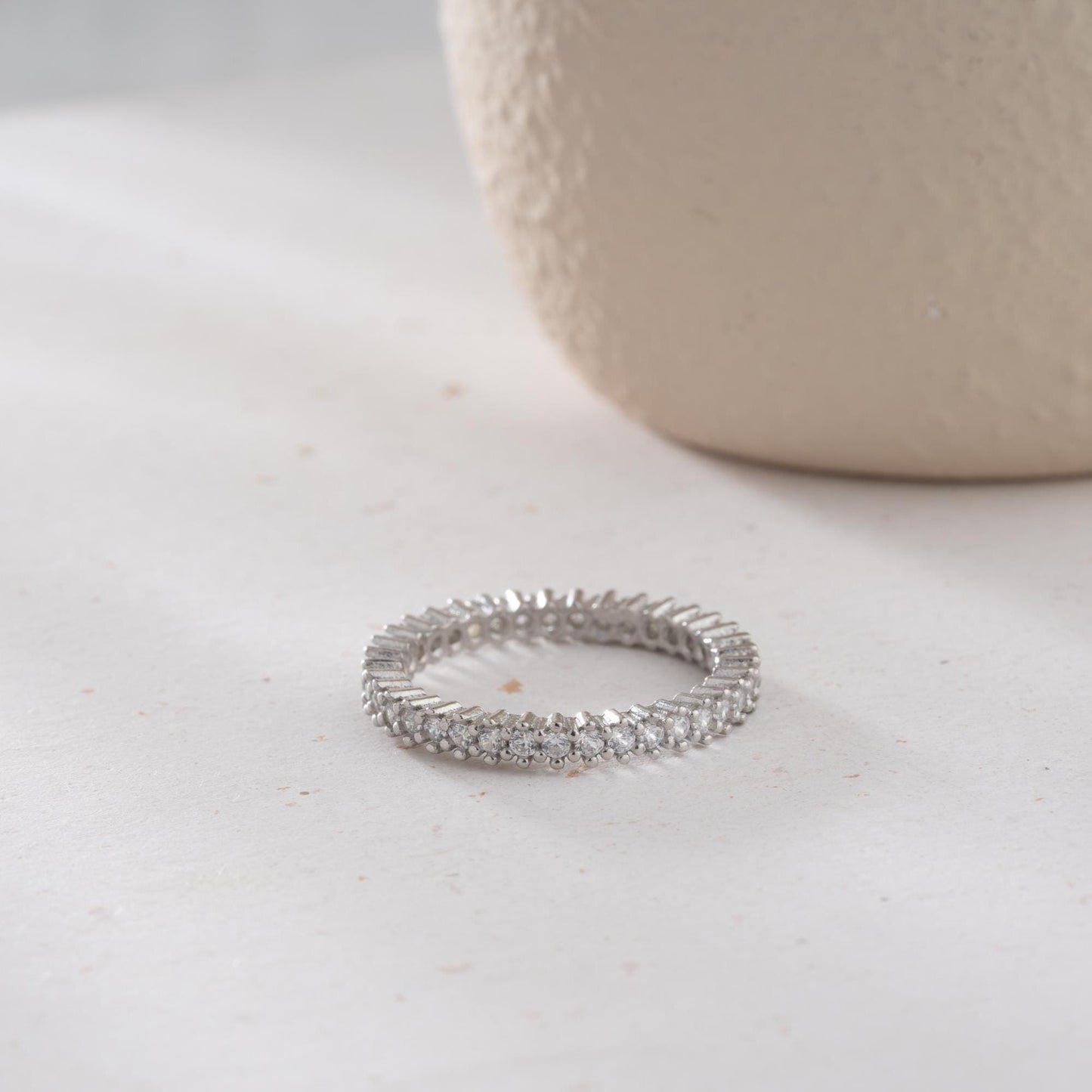 Elegant white zircon tennis ring made from 925 Sterling Silver, with brilliant stones set around the entire band. Adjustable and hypoallergenic.