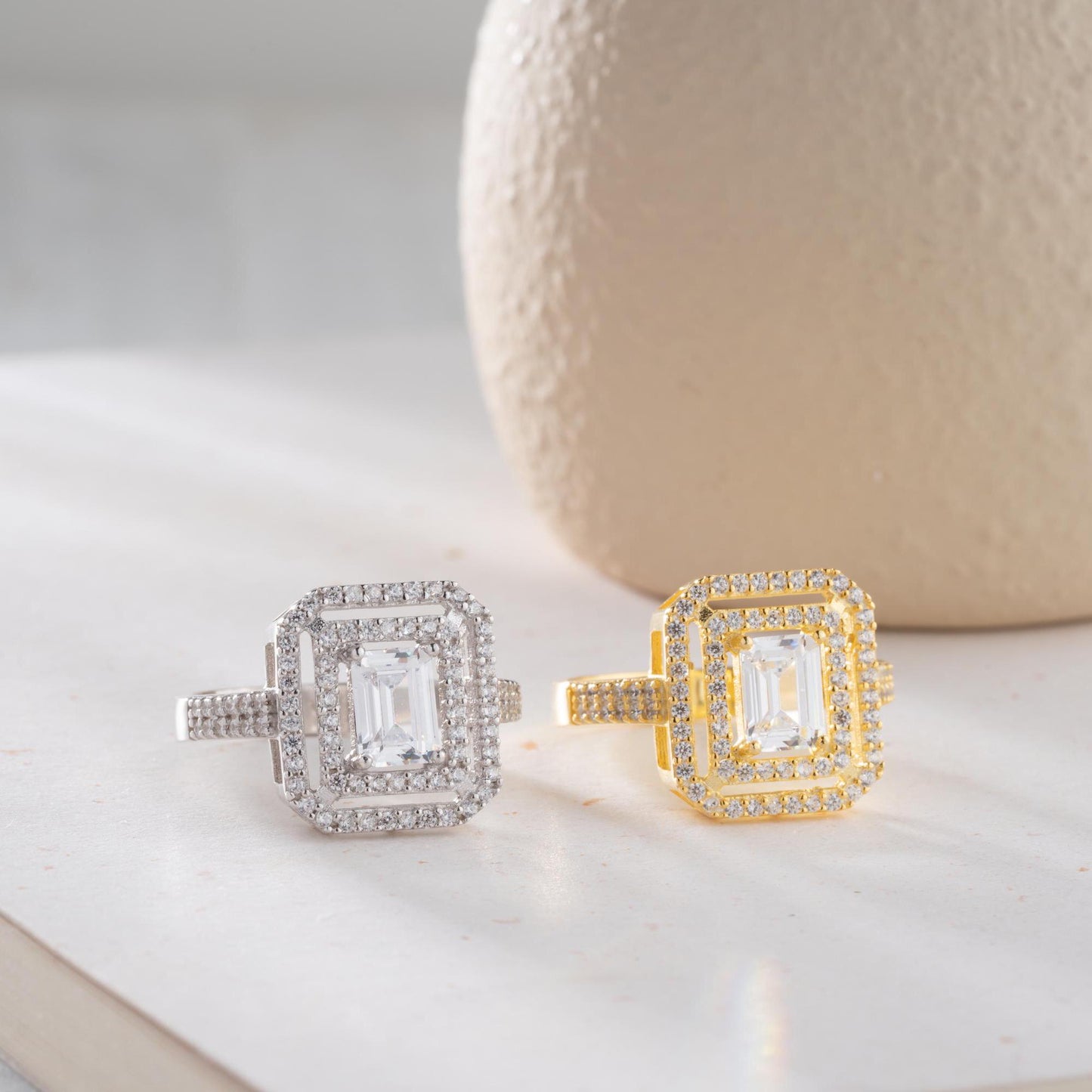 Elegant emerald cut double halo statement ring crafted in 925 sterling silver with cubic zirconia stones, available in silver and gold plated finishes.