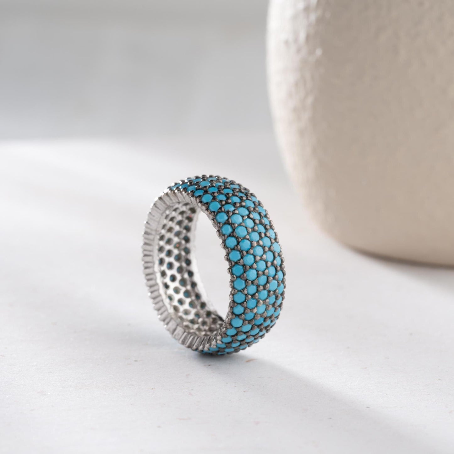 Full eternity band ring featuring pave cubic zirconia stones in clear and turquoise options, set in 925 sterling silver. A versatile, stackable piece perfect for gifting or personal wear.