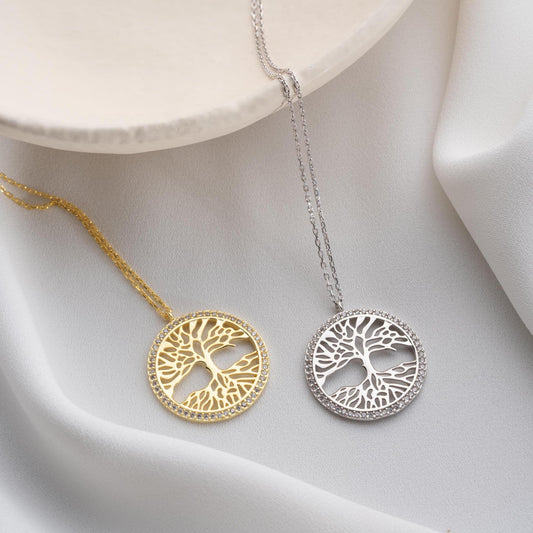 Tree of Life necklace with cubic zirconia stones, available in 925 sterling silver and 14K gold plated options, displayed on a white satin background.