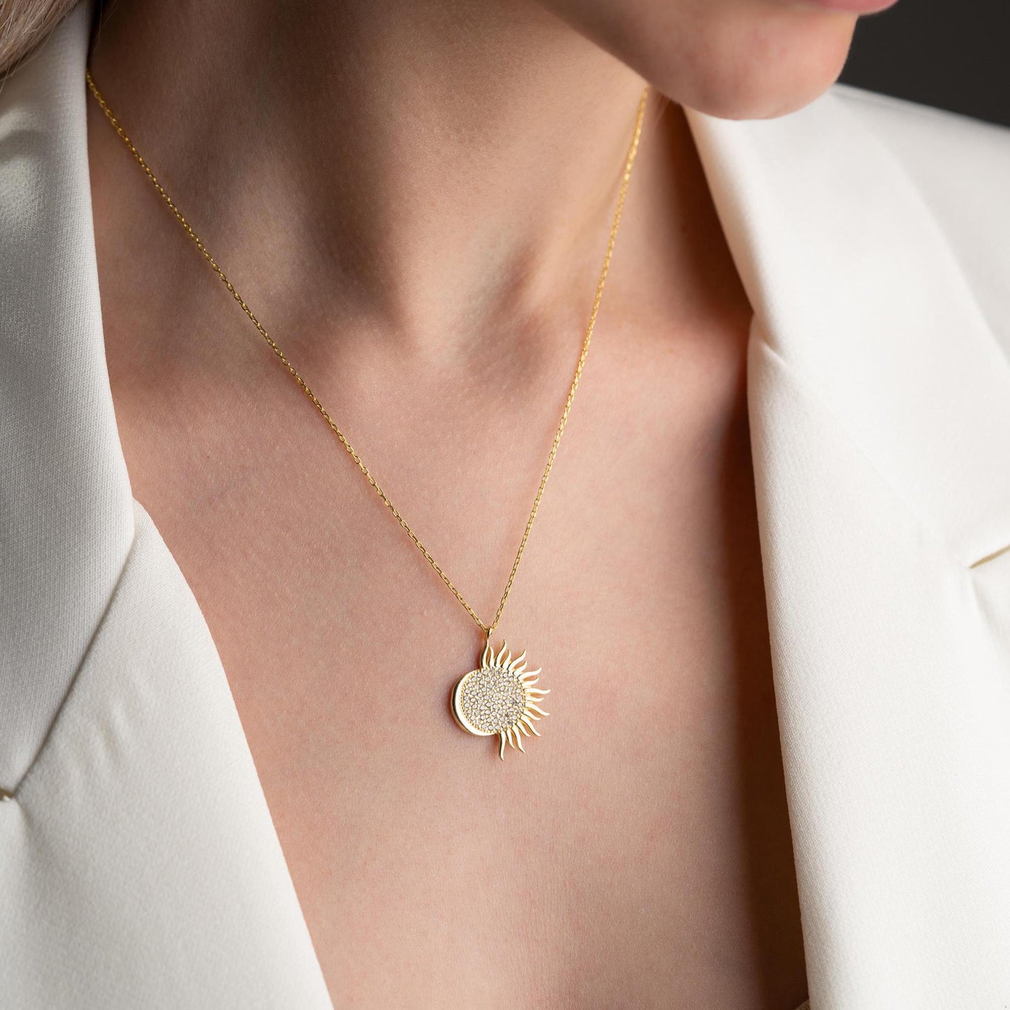 Sun pendant necklace with cubic zirconia stones, available in 925 sterling silver and 14K gold plated options, displayed on a white satin background