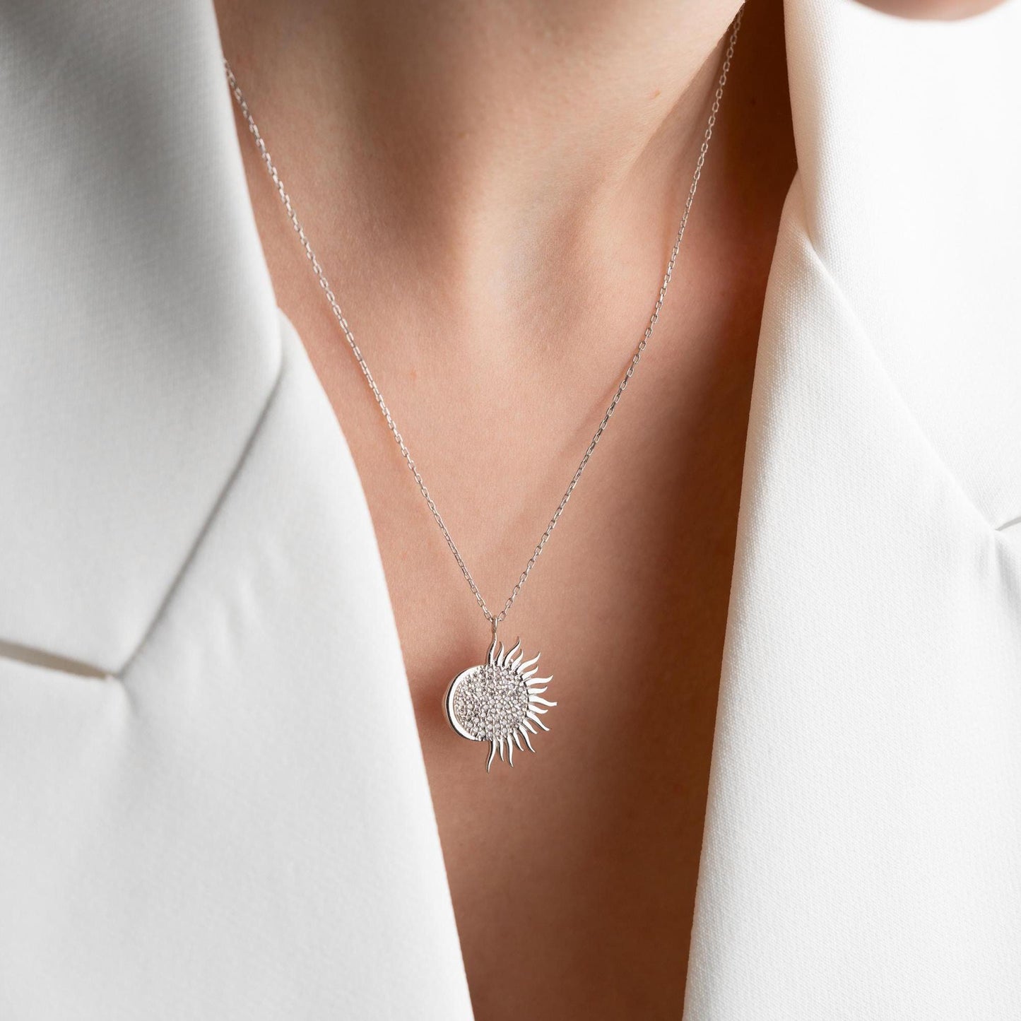 Sun pendant necklace with cubic zirconia stones, available in 925 sterling silver and 14K gold plated options, displayed on a white satin background