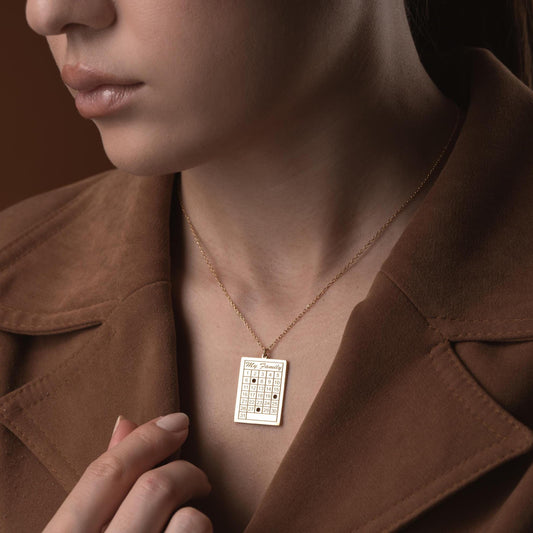 A personalized calendar necklace with a custom date engraving, available in sterling silver and gold plated finishes. The perfect anniversary, birthday, or wedding gift for her.