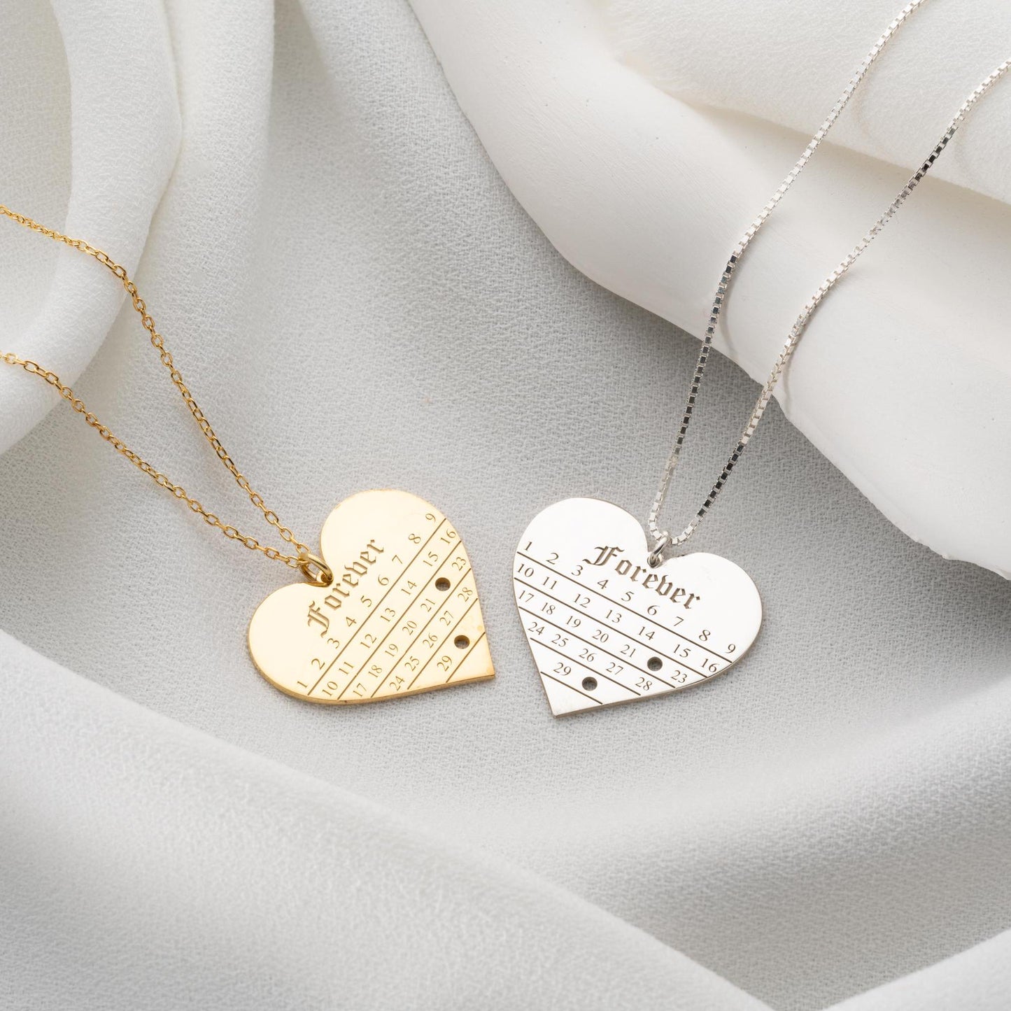 A personalized heart-shaped calendar necklace with a custom date engraving, available in sterling silver and gold plated finishes. Perfect for anniversaries, weddings, or Valentine's Day.