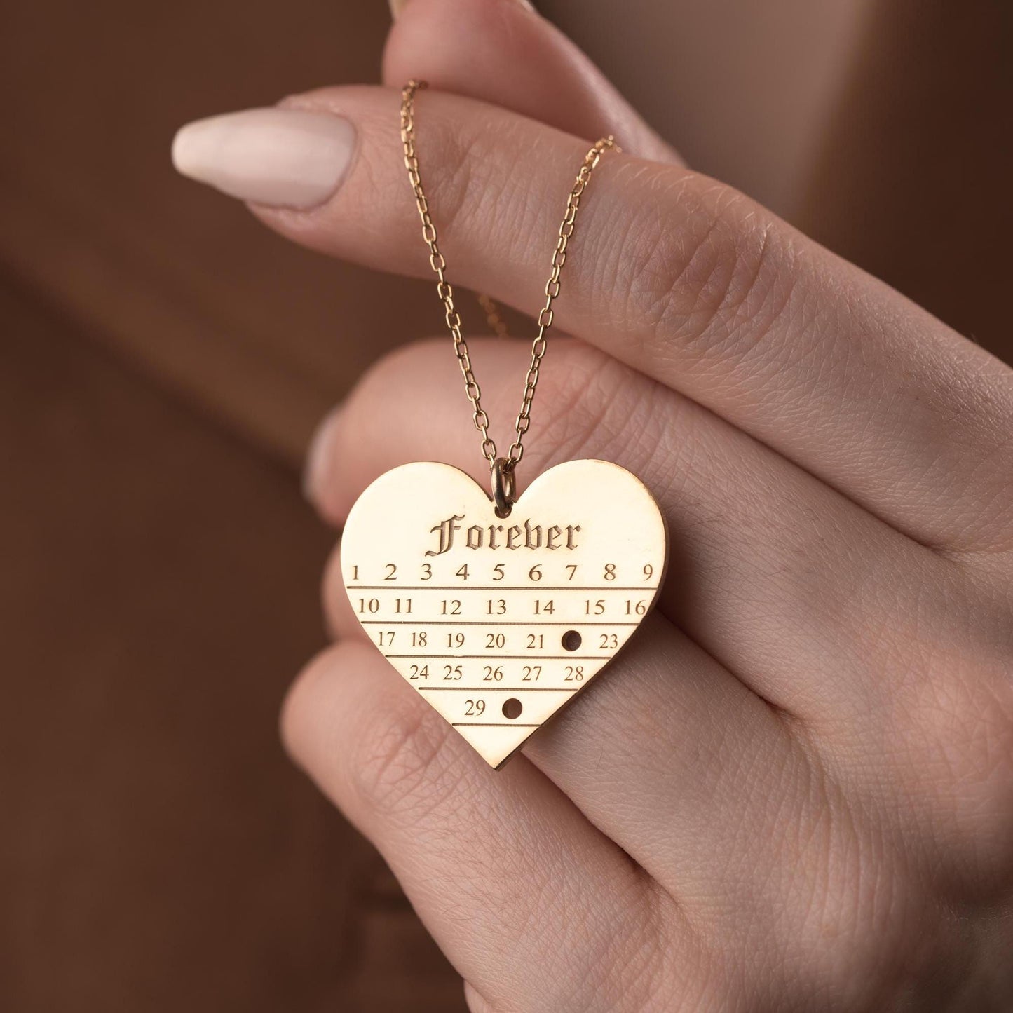 A personalized heart-shaped calendar necklace with a custom date engraving, available in sterling silver and gold plated finishes. Perfect for anniversaries, weddings, or Valentine's Day.