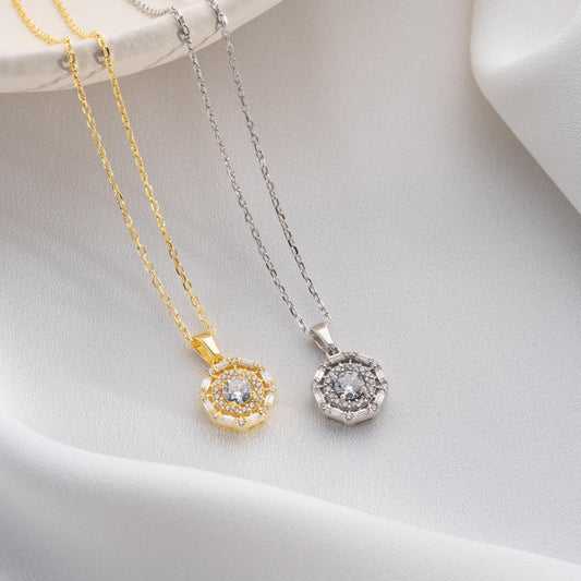 Halo pendant necklace with cubic zirconia stones, available in 925 sterling silver and 14K gold plated options, displayed on a white satin background.