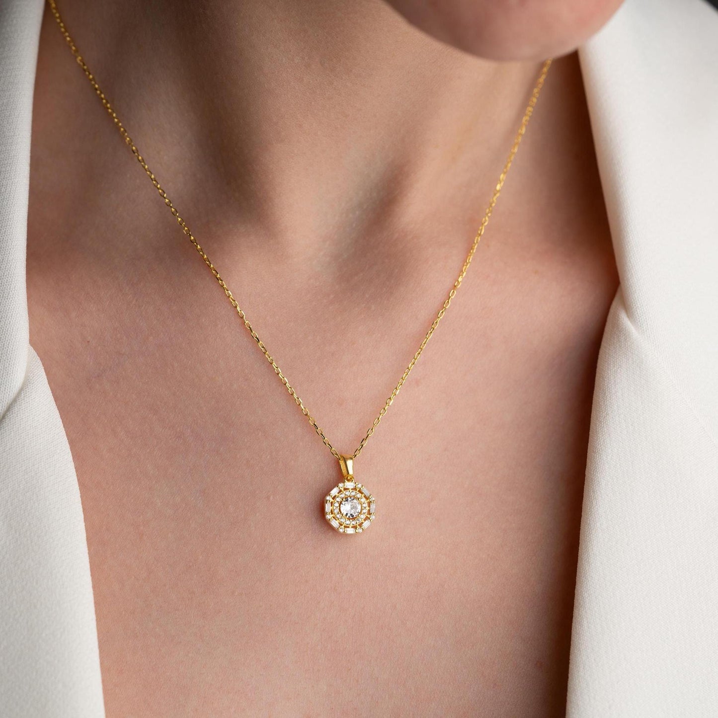 Halo pendant necklace with cubic zirconia stones, available in 925 sterling silver and 14K gold plated options, displayed on a white satin background.