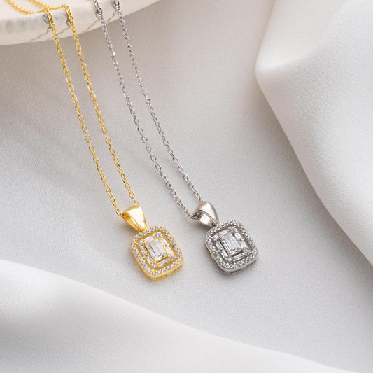Square baguette pendant necklace with cubic zirconia stones, available in 925 sterling silver and 14K gold plated options, displayed on a white satin background.