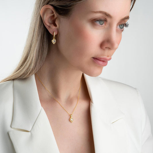 Heart pendant necklace and earrings set, crafted in 925 sterling silver with cubic zirconia stones, displayed on a soft satin background