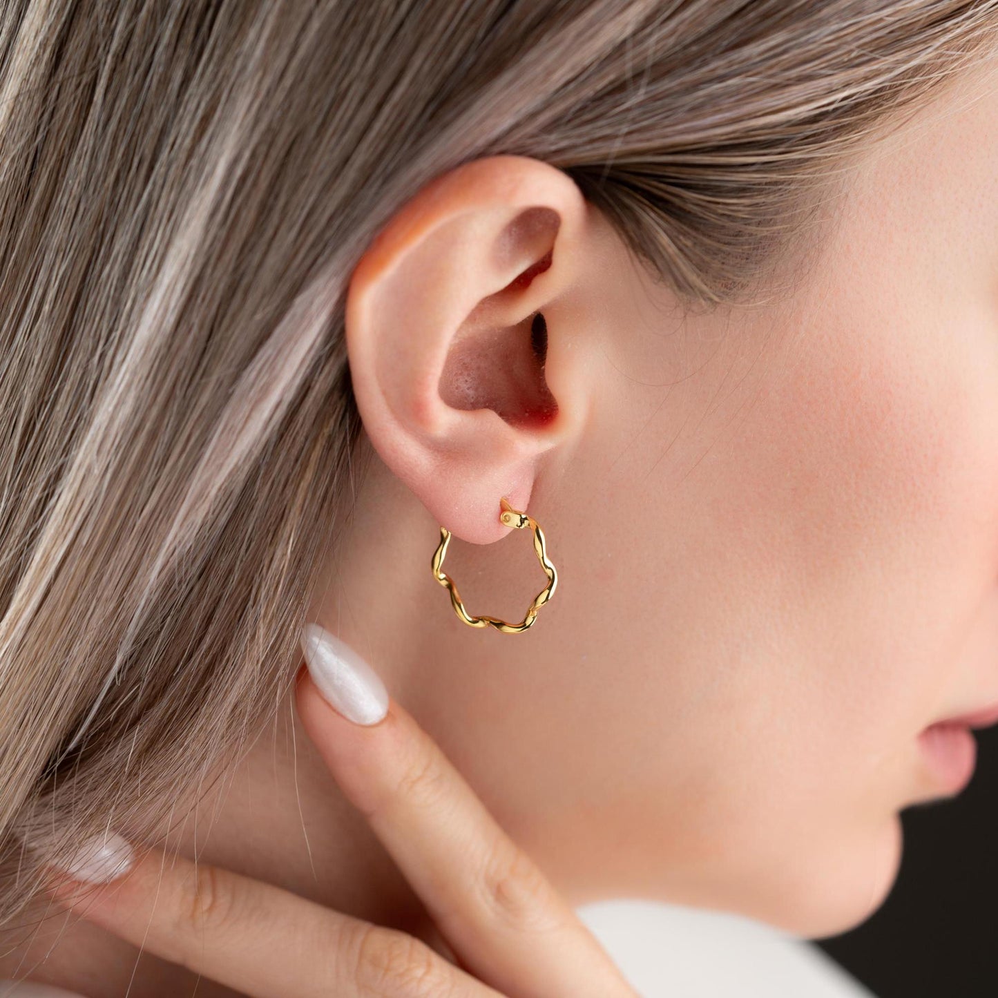 Wave hoop earrings crafted from 925 sterling silver with 14K gold plating option, displayed on a marble background.