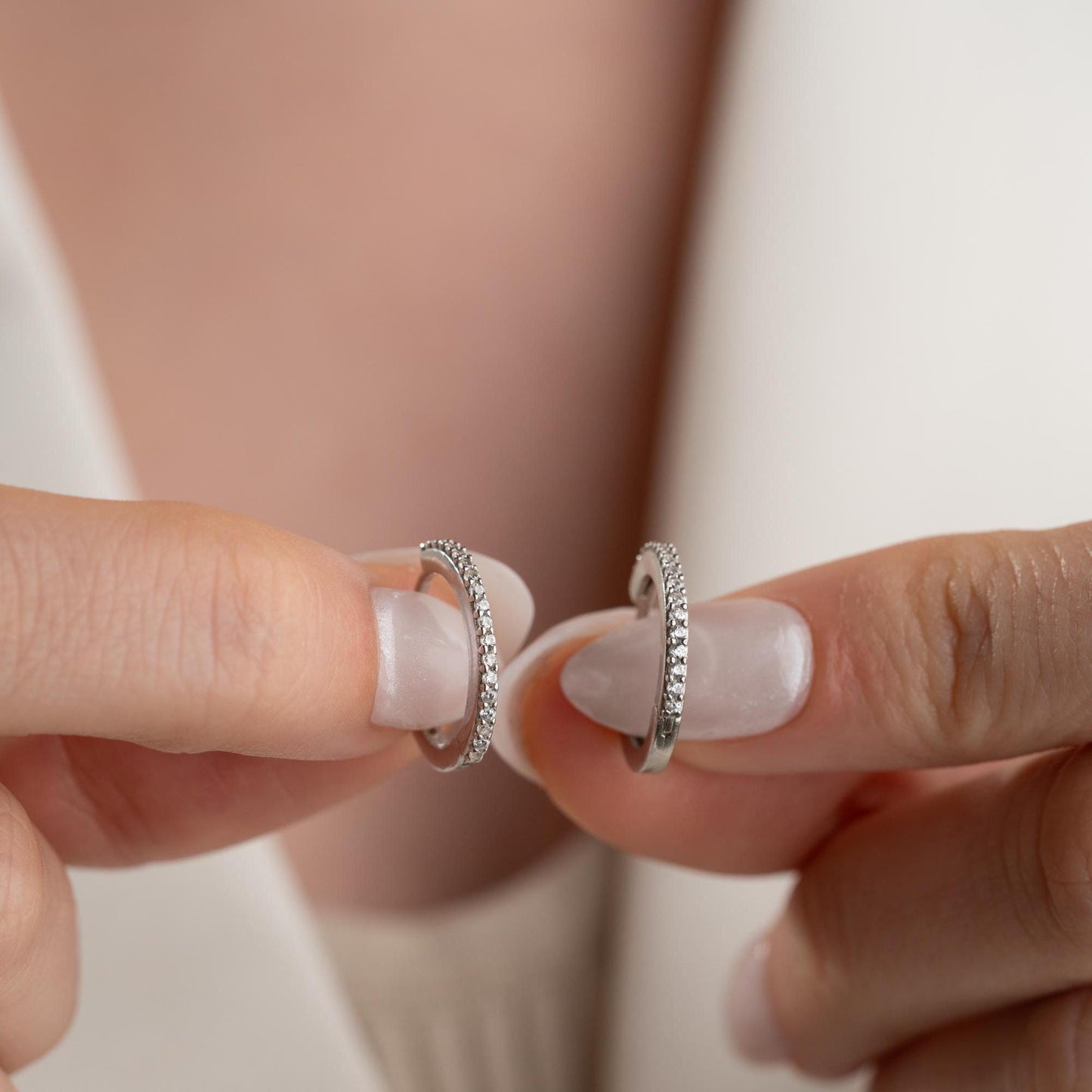 Minimalist hoop earrings with cubic zirconia stones in 925 sterling silver and 14K gold plated options, displayed on a neutral background.