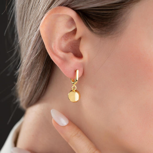 minimalist ball earrings in 925 sterling silver and 14K gold plated options, featuring a sleek design and lever-back closure displayed on a white marble background