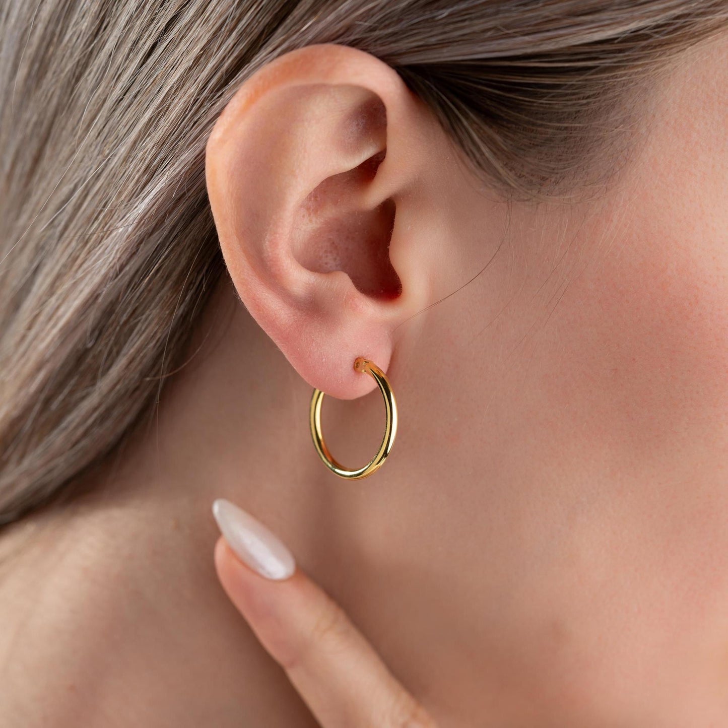 classic hoop earrings in 925 sterling silver and 14K gold plated options, featuring a minimalist polished design displayed on a marble background