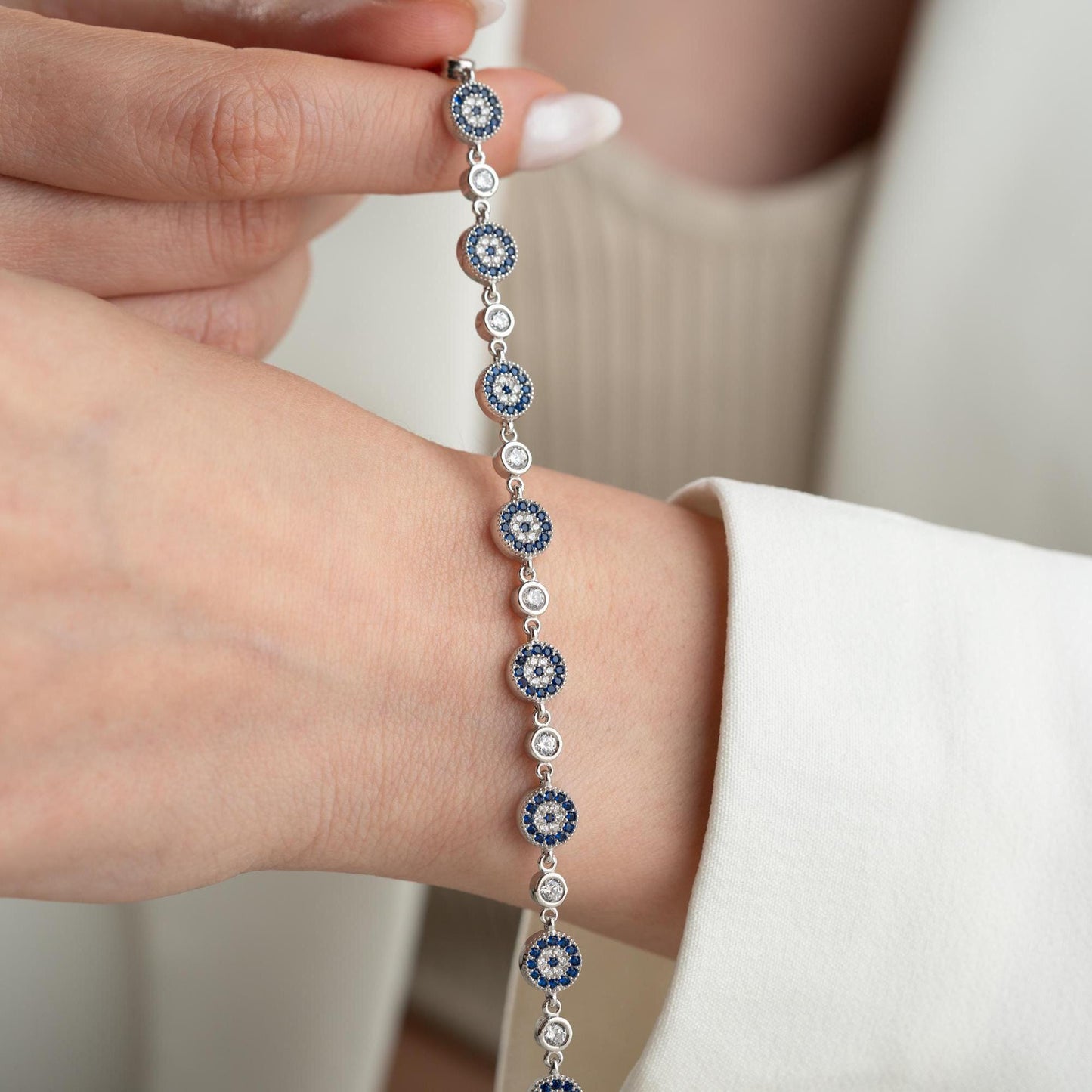 Evil Eye Charm Bracelet crafted in 925 Sterling Silver with cubic zirconia stones and intricate evil eye motifs, available in gold and silver finishes.