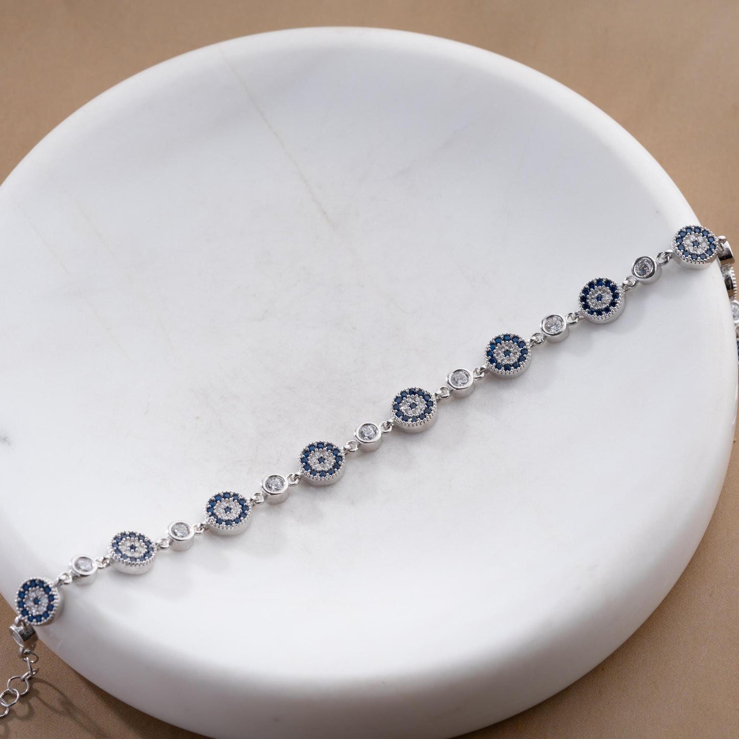 Evil Eye Charm Bracelet crafted in 925 Sterling Silver with cubic zirconia stones and intricate evil eye motifs, available in gold and silver finishes.