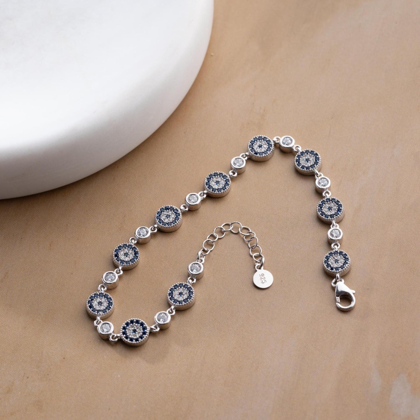 Evil Eye Charm Bracelet crafted in 925 Sterling Silver with cubic zirconia stones and intricate evil eye motifs, available in gold and silver finishes.