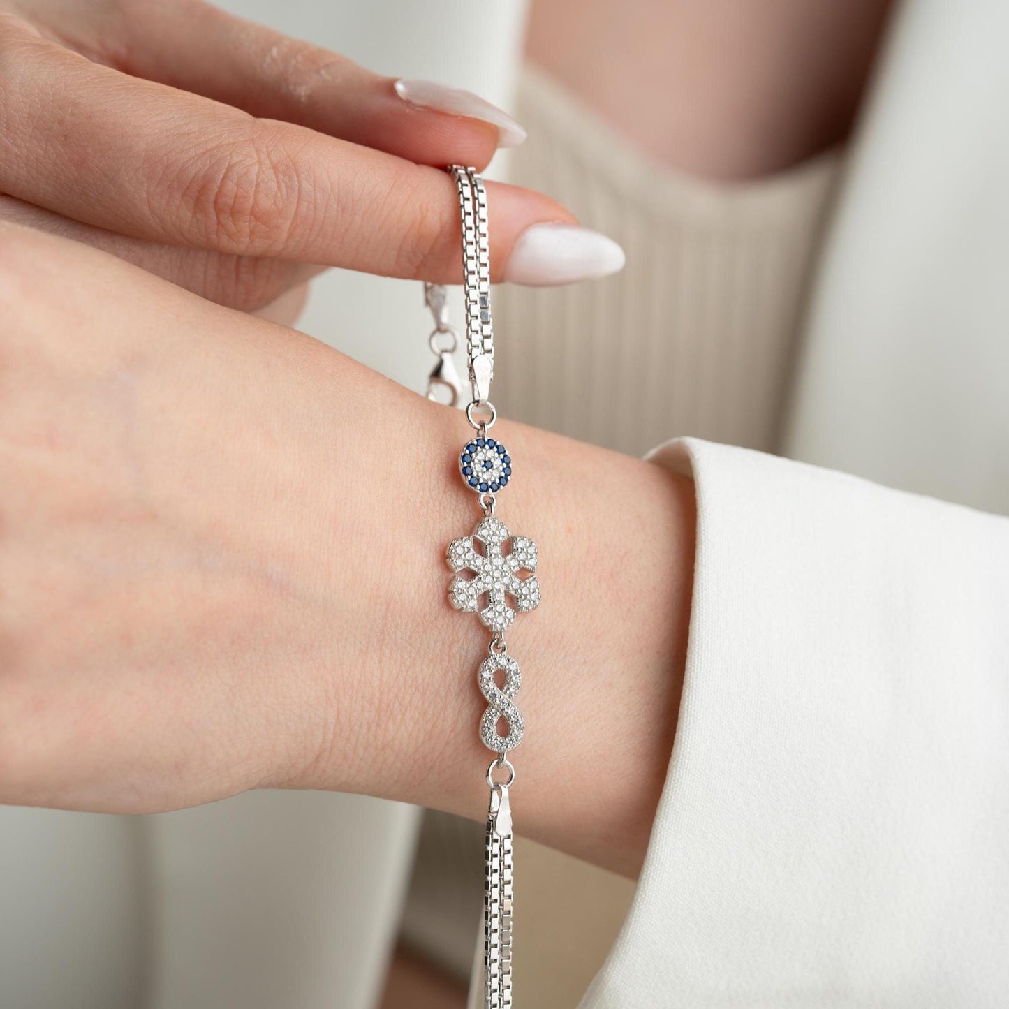 Double chain bracelet with snowflake, infinity, and evil eye charms, crafted in 925 Sterling Silver and 14K Gold Plated, perfect for Christmas or special occasions.