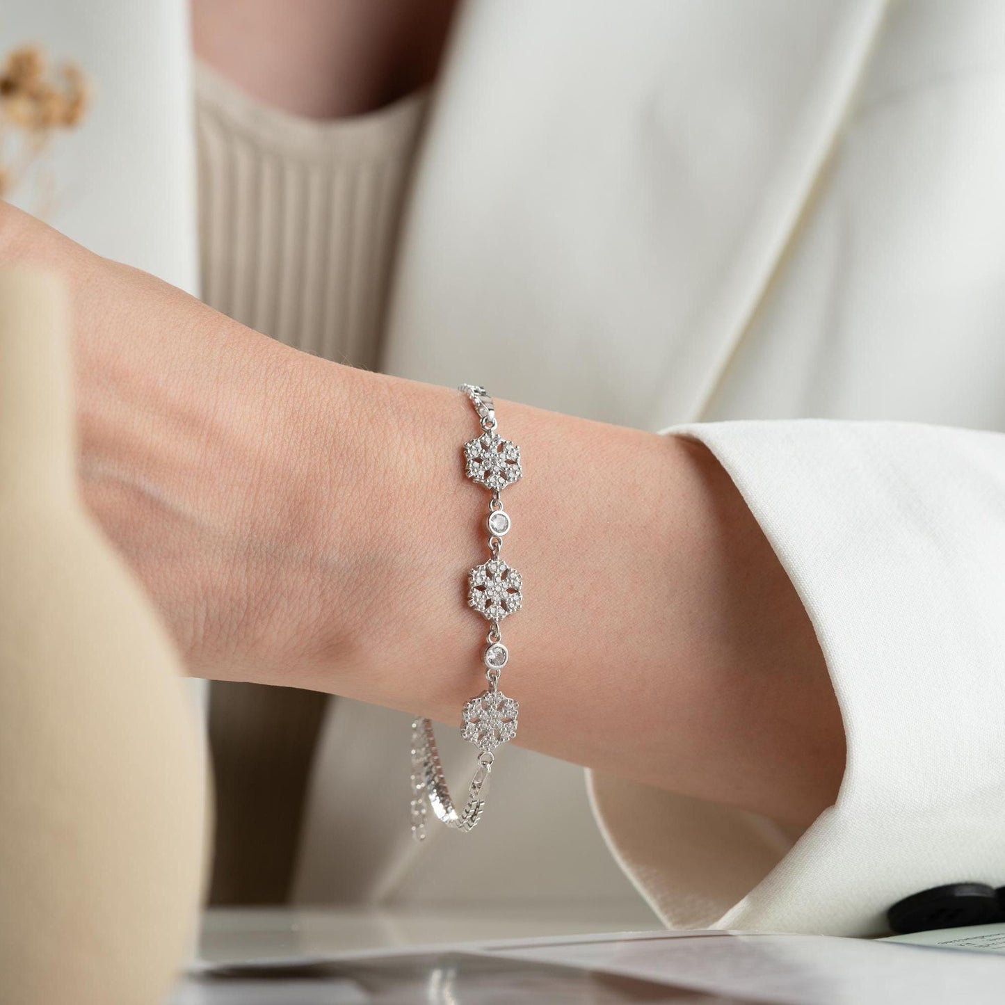 Elegant snowflake charm bracelet crafted in 925 Sterling Silver with cubic zirconia stones, available in silver and gold finishes, perfect for winter gifting.