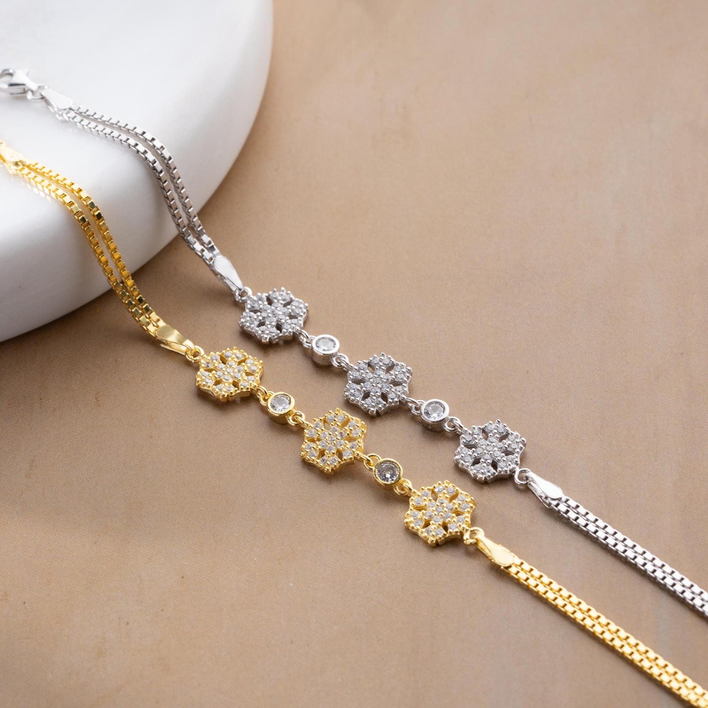 Elegant snowflake charm bracelet crafted in 925 Sterling Silver with cubic zirconia stones, available in silver and gold finishes, perfect for winter gifting.