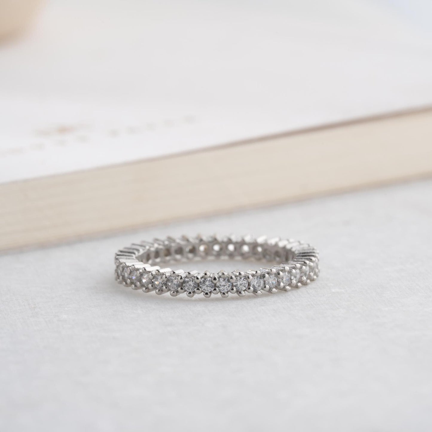Elegant white zircon tennis ring made from 925 Sterling Silver, with brilliant stones set around the entire band. Adjustable and hypoallergenic.