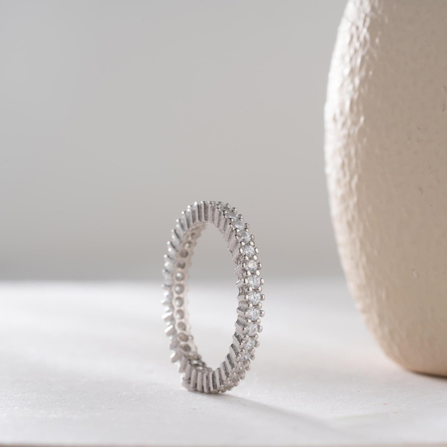 Elegant white zircon tennis ring made from 925 Sterling Silver, with brilliant stones set around the entire band. Adjustable and hypoallergenic.