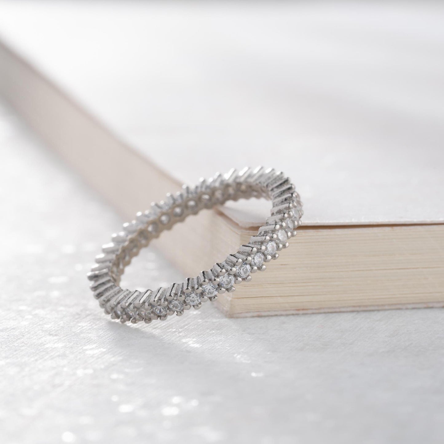 Elegant white zircon tennis ring made from 925 Sterling Silver, with brilliant stones set around the entire band. Adjustable and hypoallergenic.