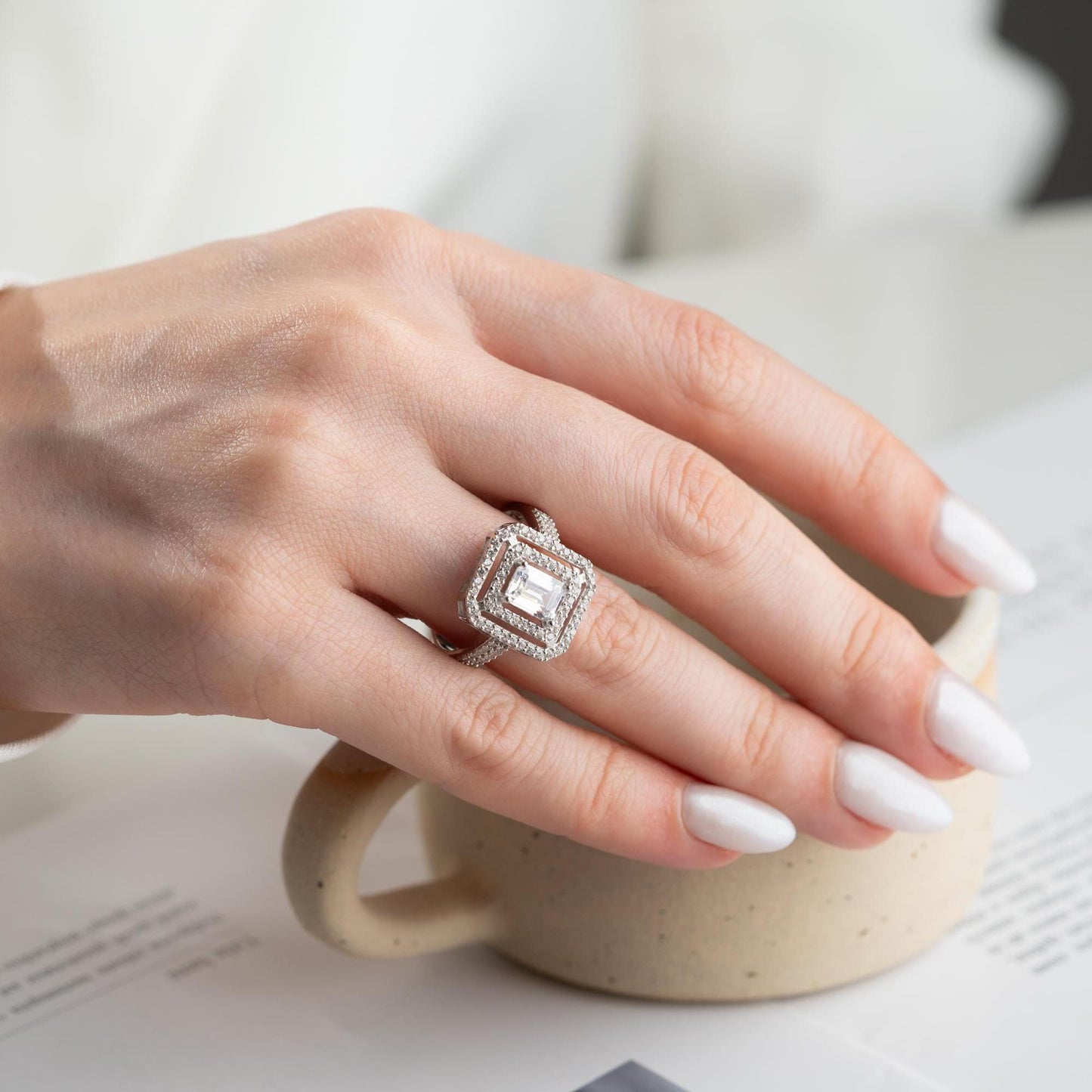 Elegant emerald cut double halo statement ring crafted in 925 sterling silver with cubic zirconia stones, available in silver and gold plated finishes.