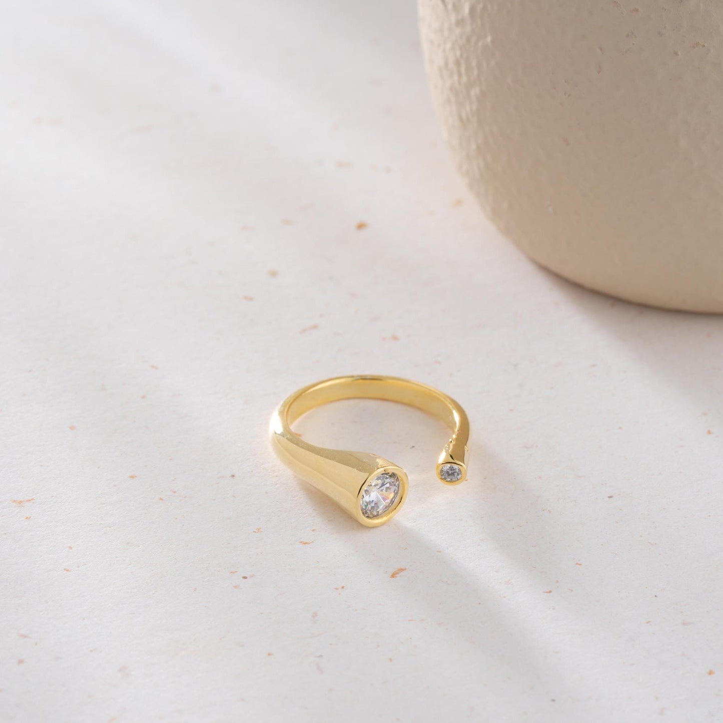Elegant open ring with dual bezel-set zircon stones, crafted from 925 sterling silver and available in gold plated and silver finishes.
