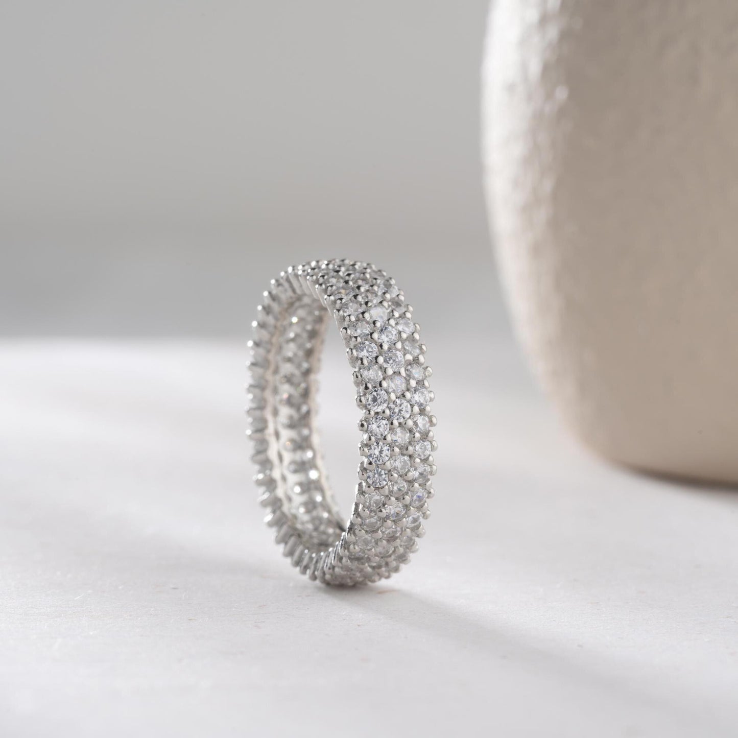 Full eternity band ring featuring pave cubic zirconia stones in clear and turquoise options, set in 925 sterling silver. A versatile, stackable piece perfect for gifting or personal wear.