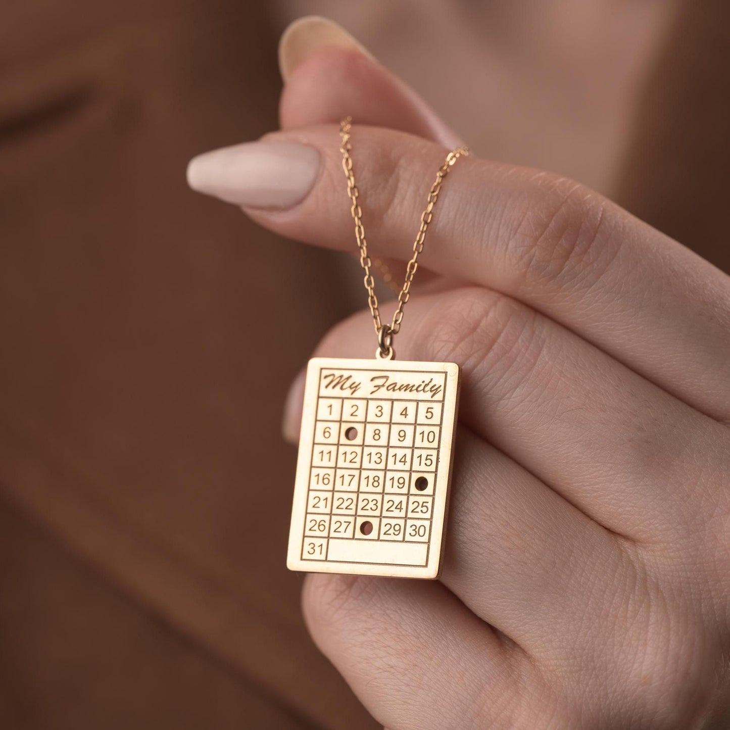 A personalized calendar necklace with a custom date engraving, available in sterling silver and gold plated finishes. The perfect anniversary, birthday, or wedding gift for her.