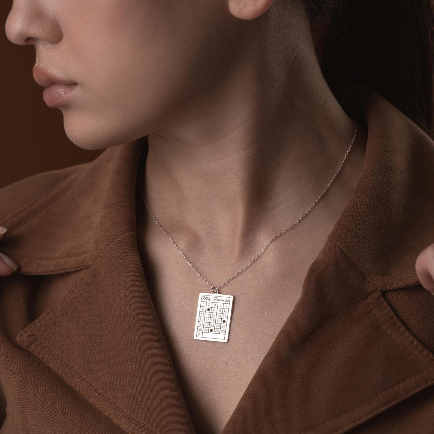 A personalized calendar necklace with a custom date engraving, available in sterling silver and gold plated finishes. The perfect anniversary, birthday, or wedding gift for her.
