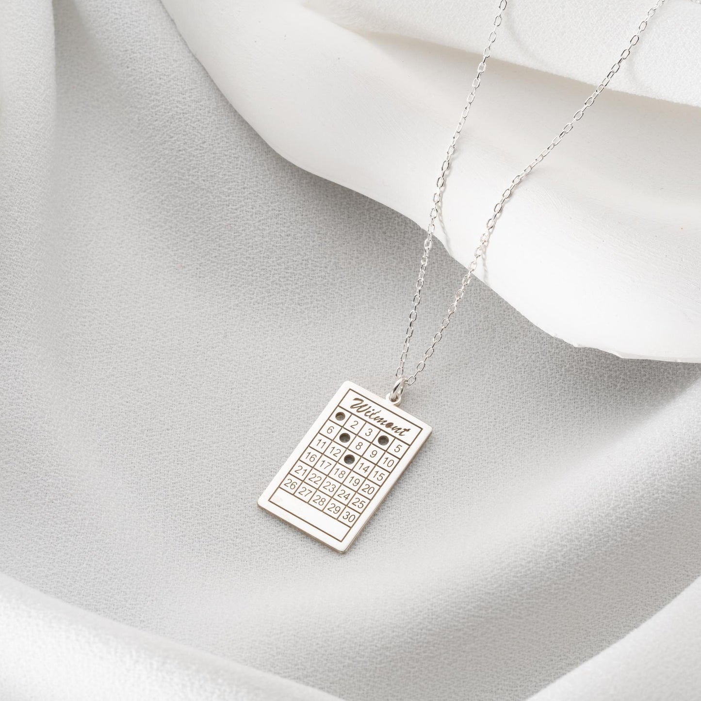 A rectangular calendar pendant necklace, engraved with a custom date and name, crafted from 925 Sterling Silver or 14K Gold Plated. Ideal for anniversaries, weddings, and birthday gifts.