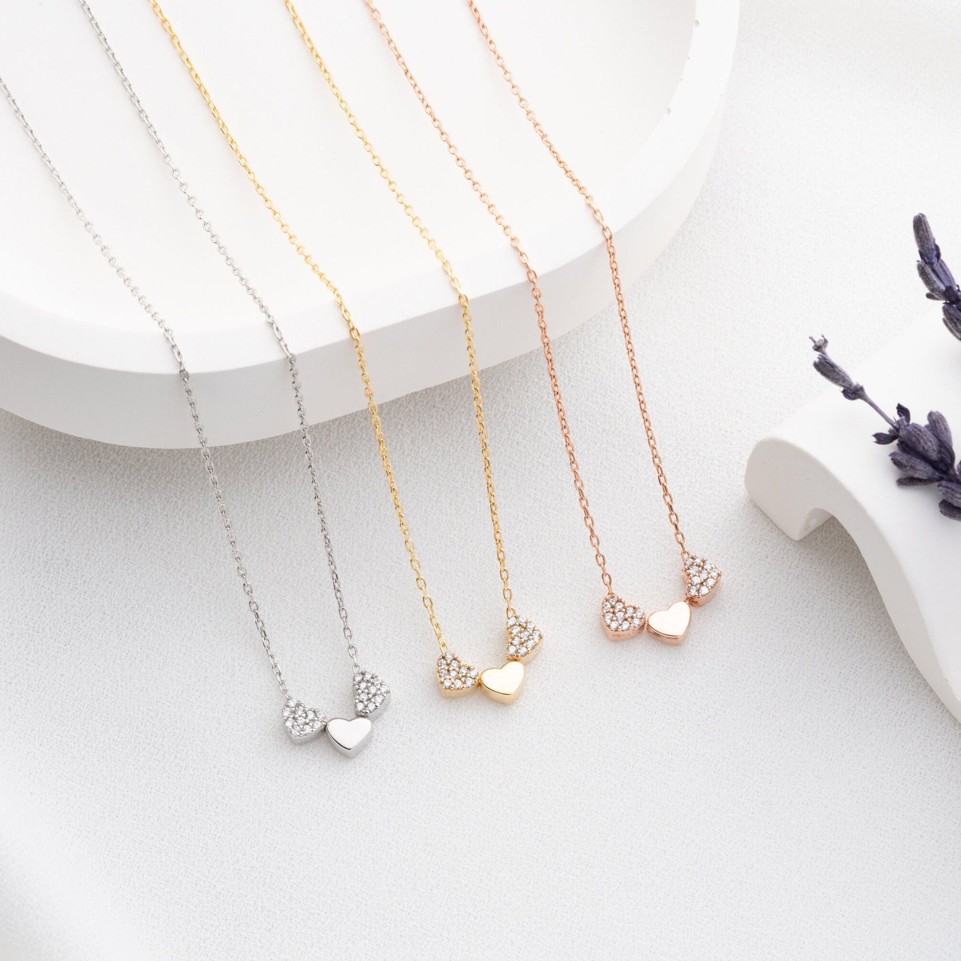 An exquisite silver necklace featuring three interlocking hearts, each heart intricately detailed with sparkling zircon stones, creating a luxurious and romantic piece perfect for gifting on special occasions or expressing love and affection.