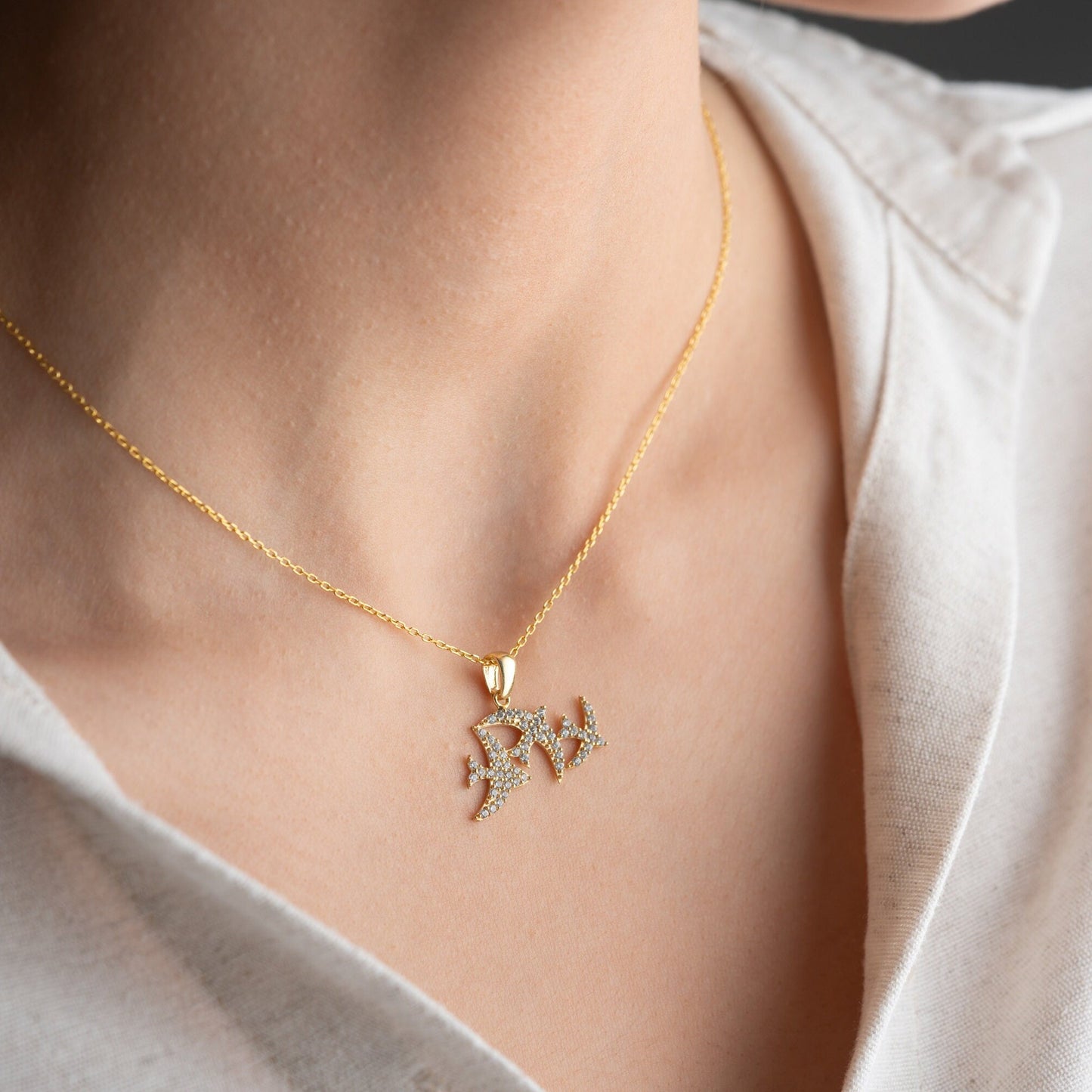 Elegant three seagulls silver necklace with sparkling zircon gemstones detail on a light background.