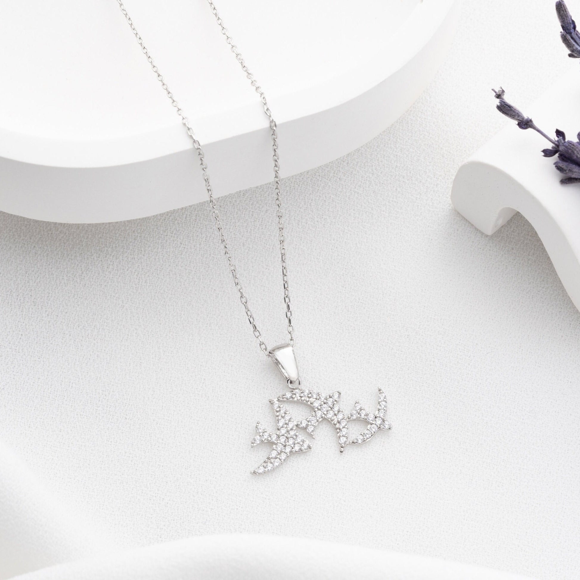 Elegant three seagulls silver necklace with sparkling zircon gemstones detail on a light background.