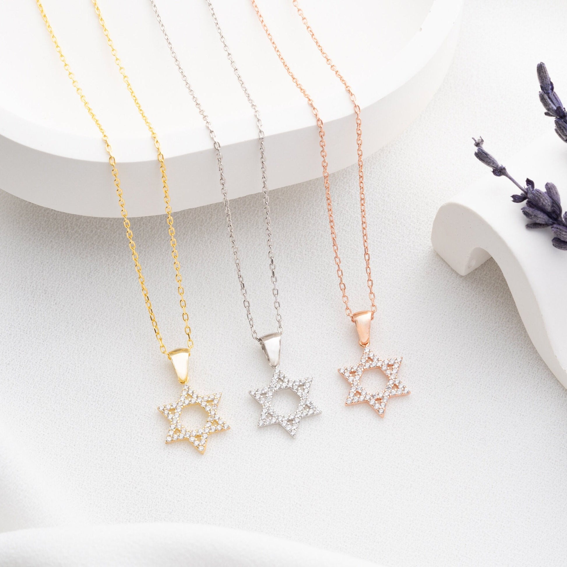 Close-up of a sparkling zircon-embellished Star of David pendant made of 925 sterling silver against a soft white background.